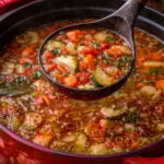 Weight Loss Soup in a red dutch oven with a spoon lifting up some