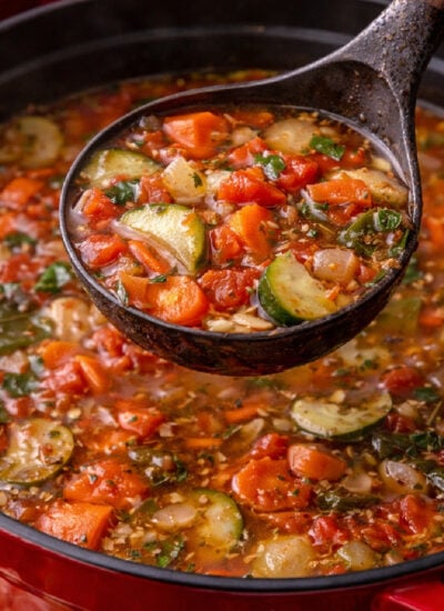 Weight Loss Soup in a red dutch oven with a spoon lifting up some