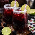 Blackberry Margaritas on a dark wood cutting board