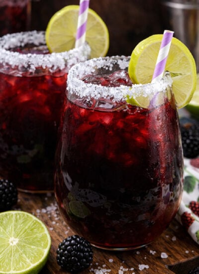 Blackberry Margaritas on a dark wood cutting board