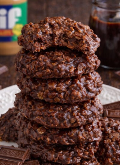 Chocolate Peanut Butter No Bake Cookies on a white plate stacked with a bite missing from the top one