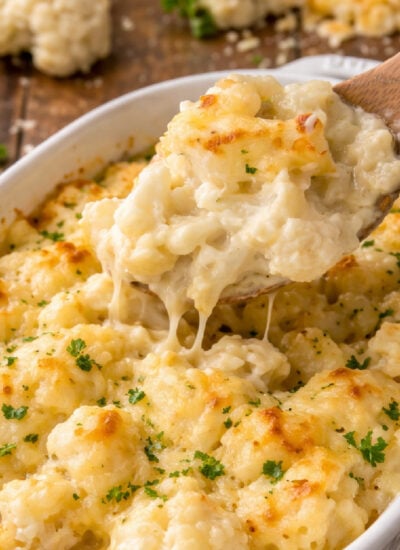 up close shot of the Cheesy Cauliflower Casserole with a spoon lifting up some