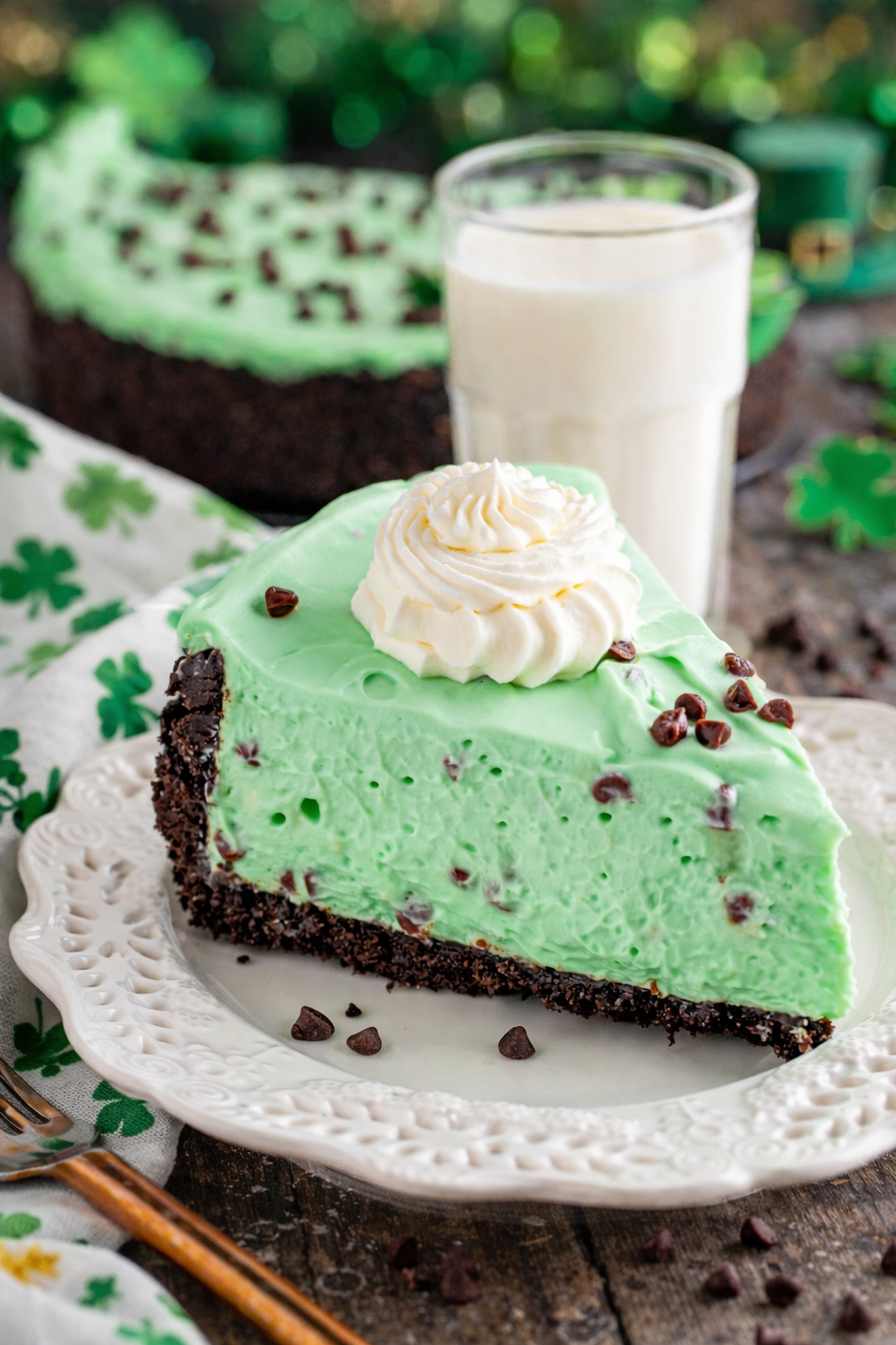 No Bake Mint Chocolate Chip Cheesecake on a white plate with st paddys day decor 