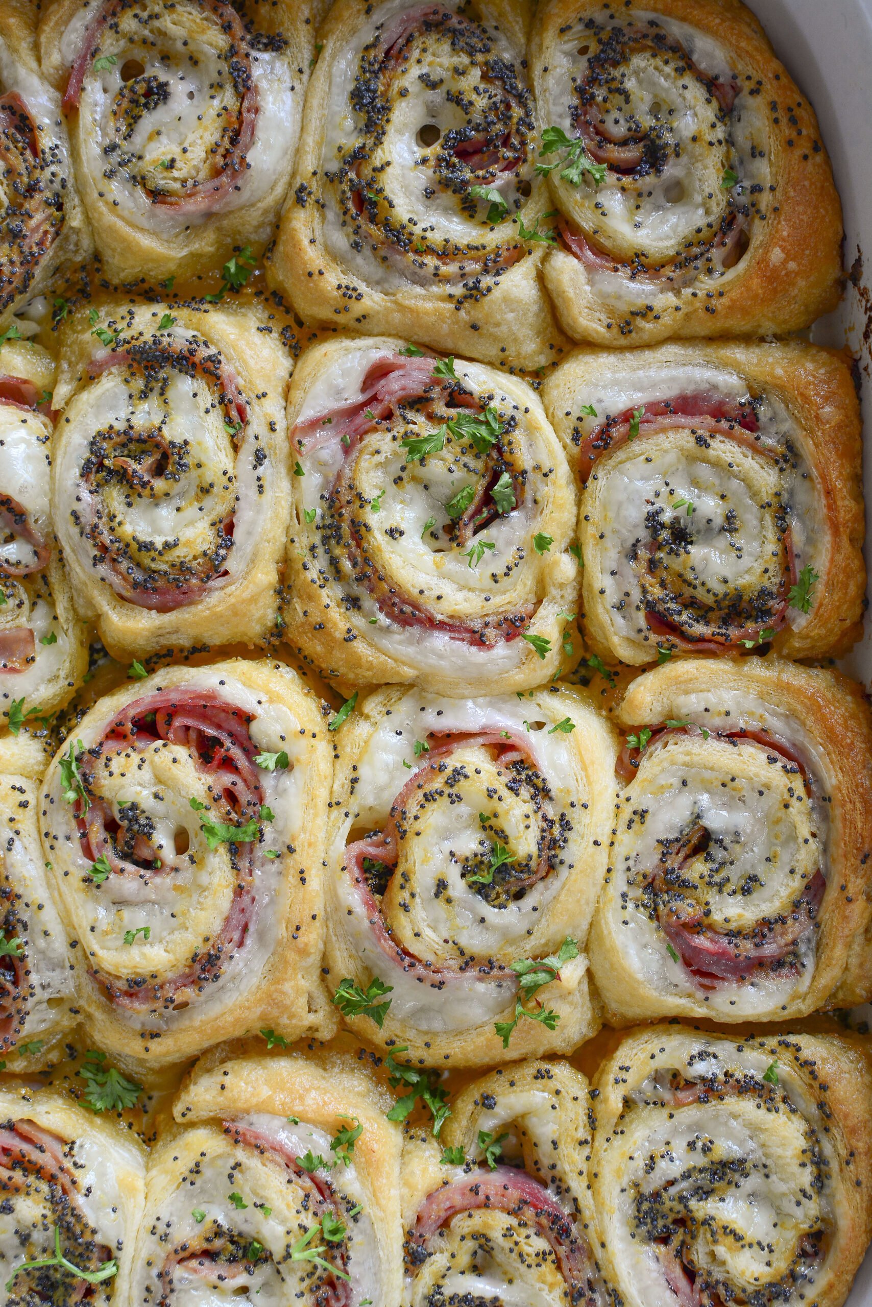 Ham and Cheese Pinwheels in a white baking dish overhead photo