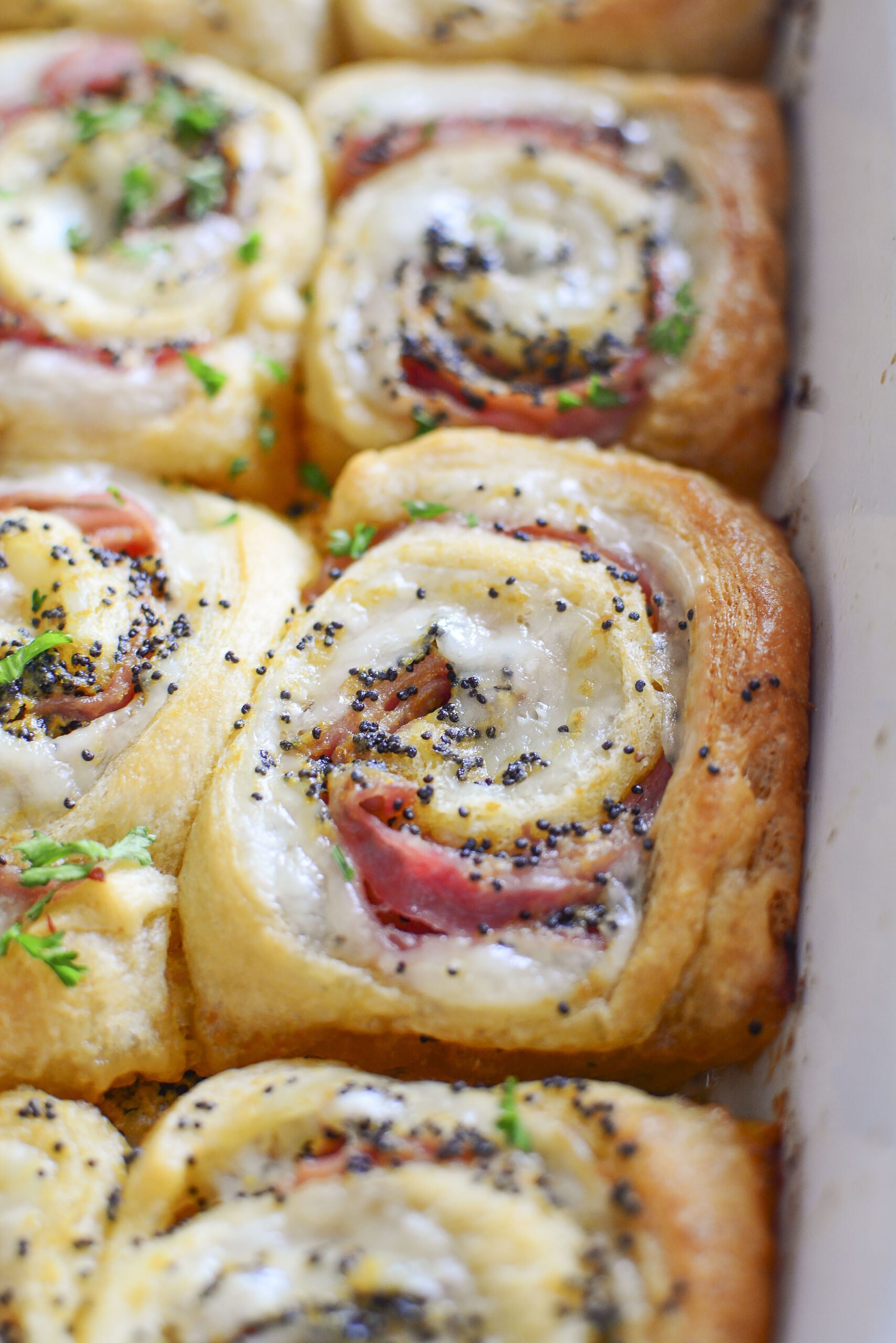 Ham and Cheese Pinwheels in a white baking dish close up shot