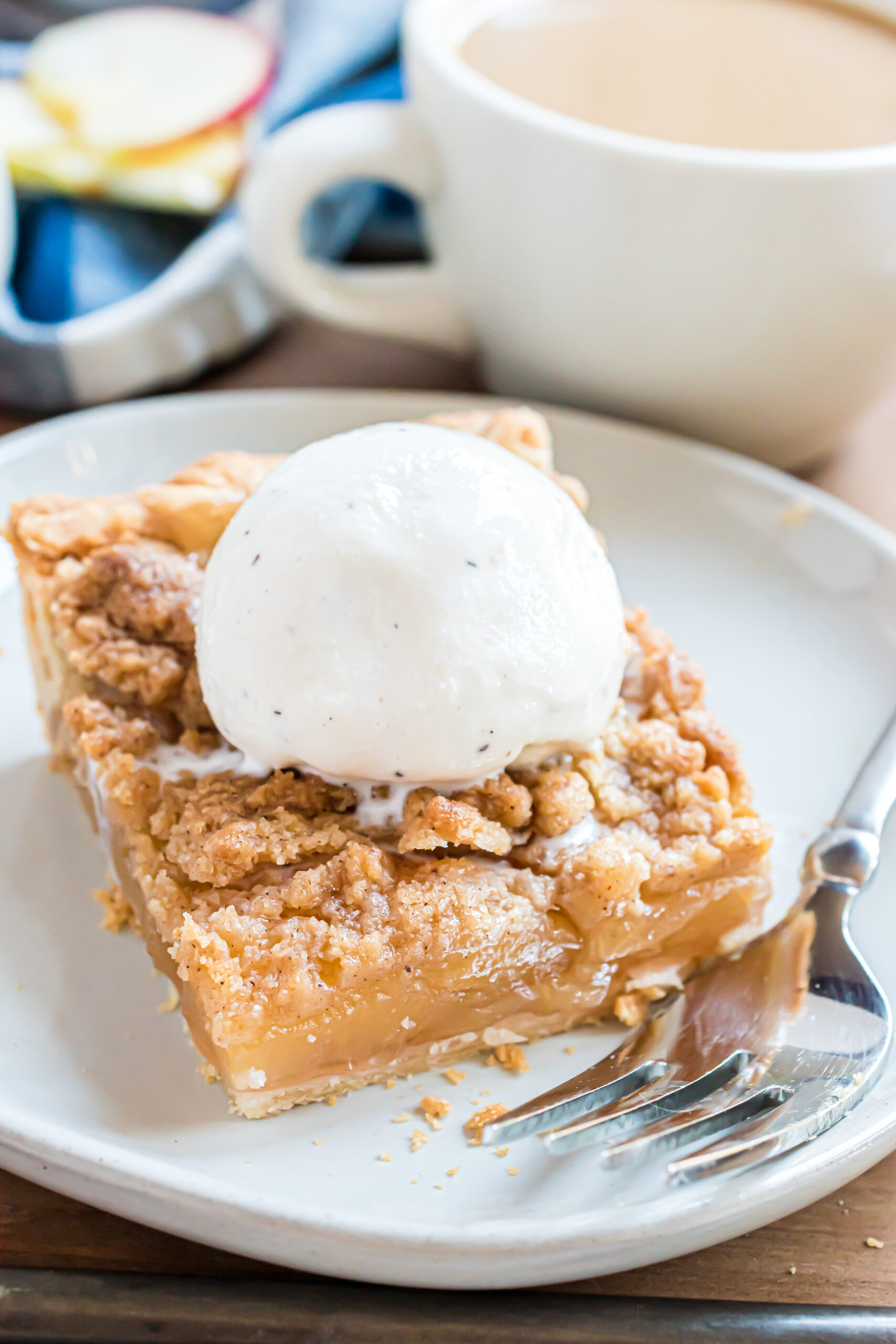 Up close shot of the apple slab pie on a white plate topped with vanilla ice cream 