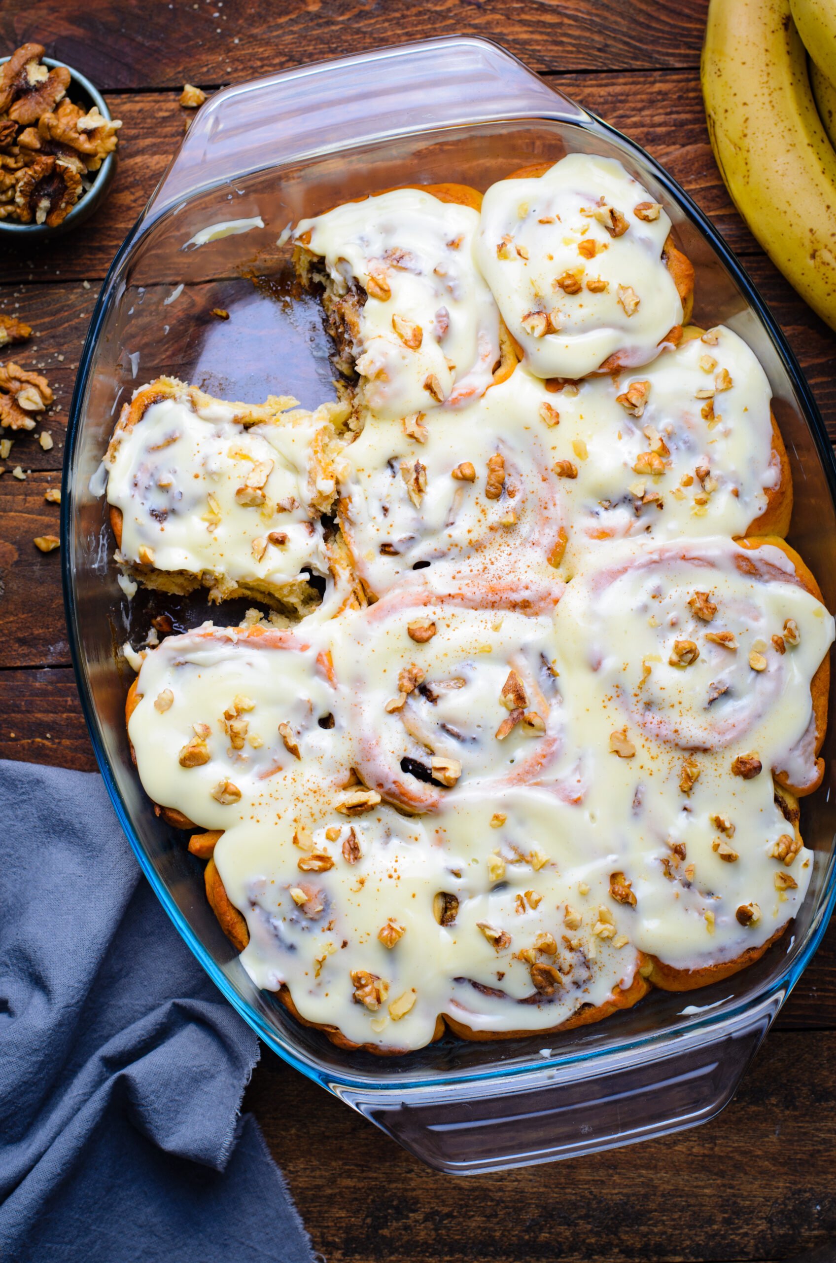 Overhead view of Banana Nut Cinnamon Rolls in a clear baking dish.