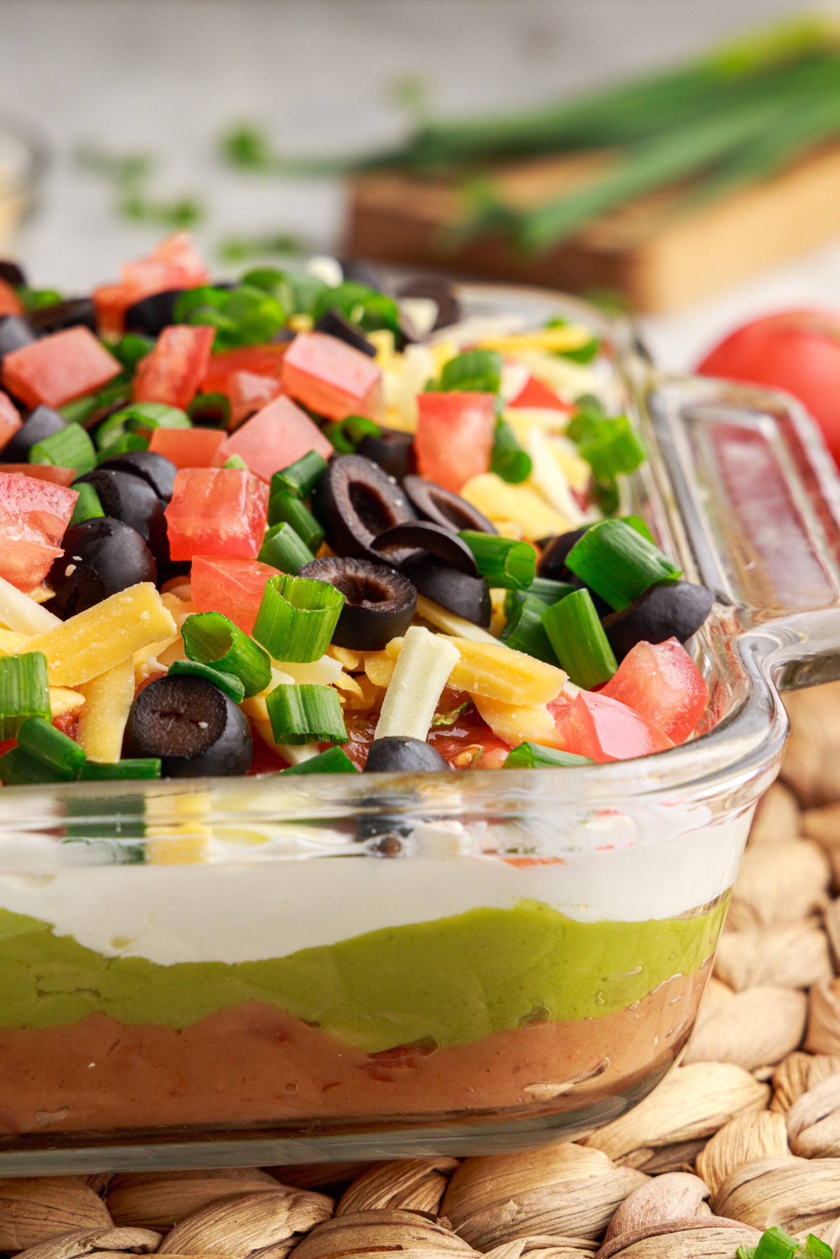 Close up view of 7-Layer Dip in a clear baking dish.