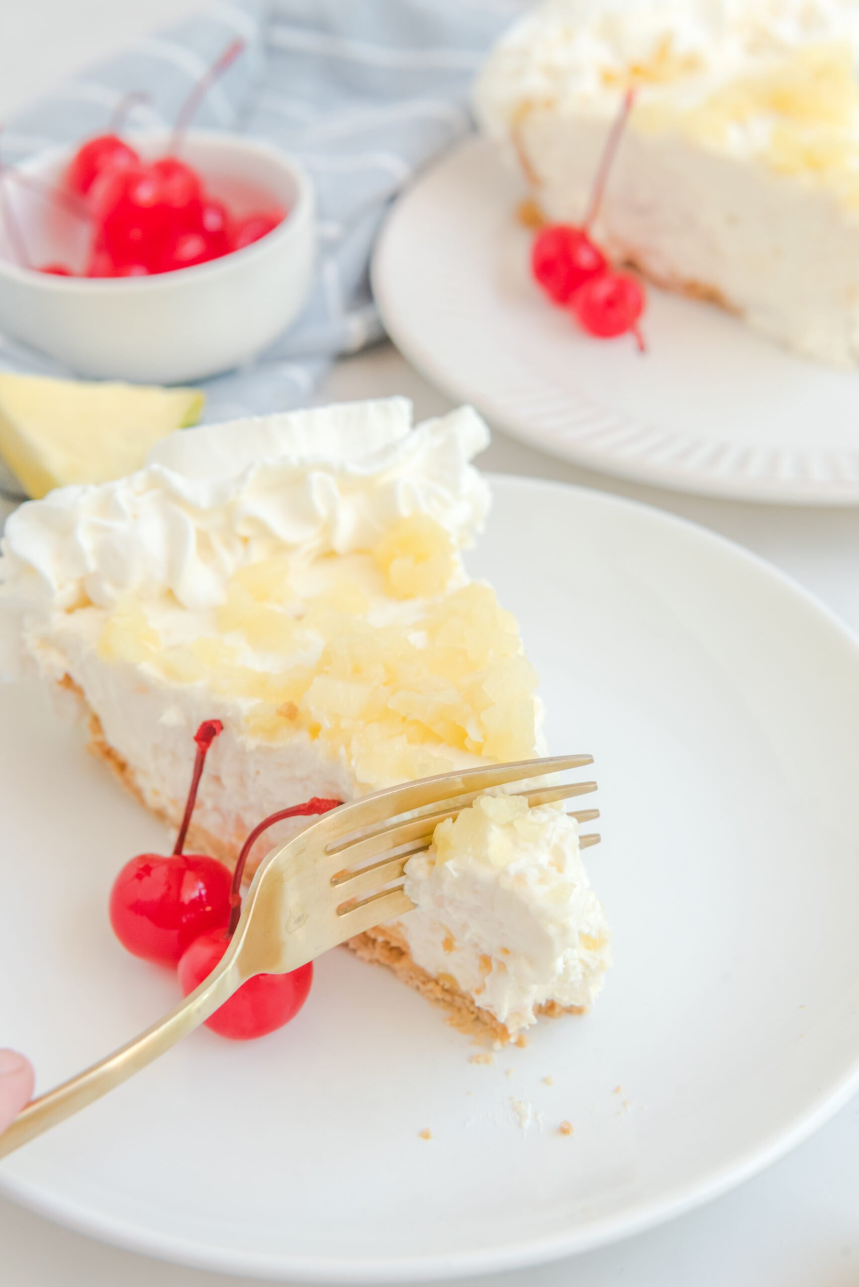 Up close view of a gold fork removing a bite of No Bake Pineapple Cheesecake.