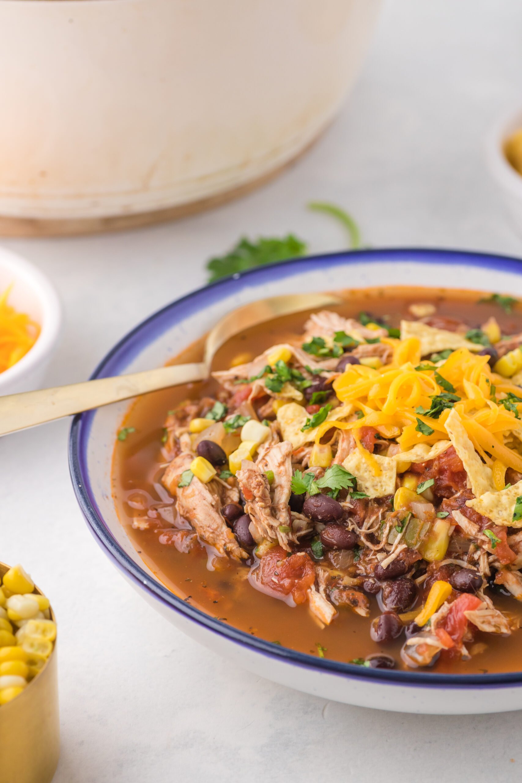 Close up view of Chicken Taco Soup in a bowl served with a golden spoon.