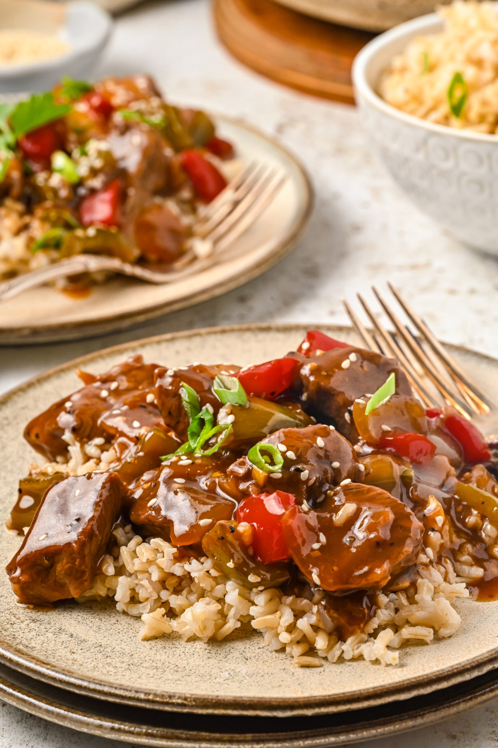 Front view of Chinese Pepper Steak on a dish served over rice.