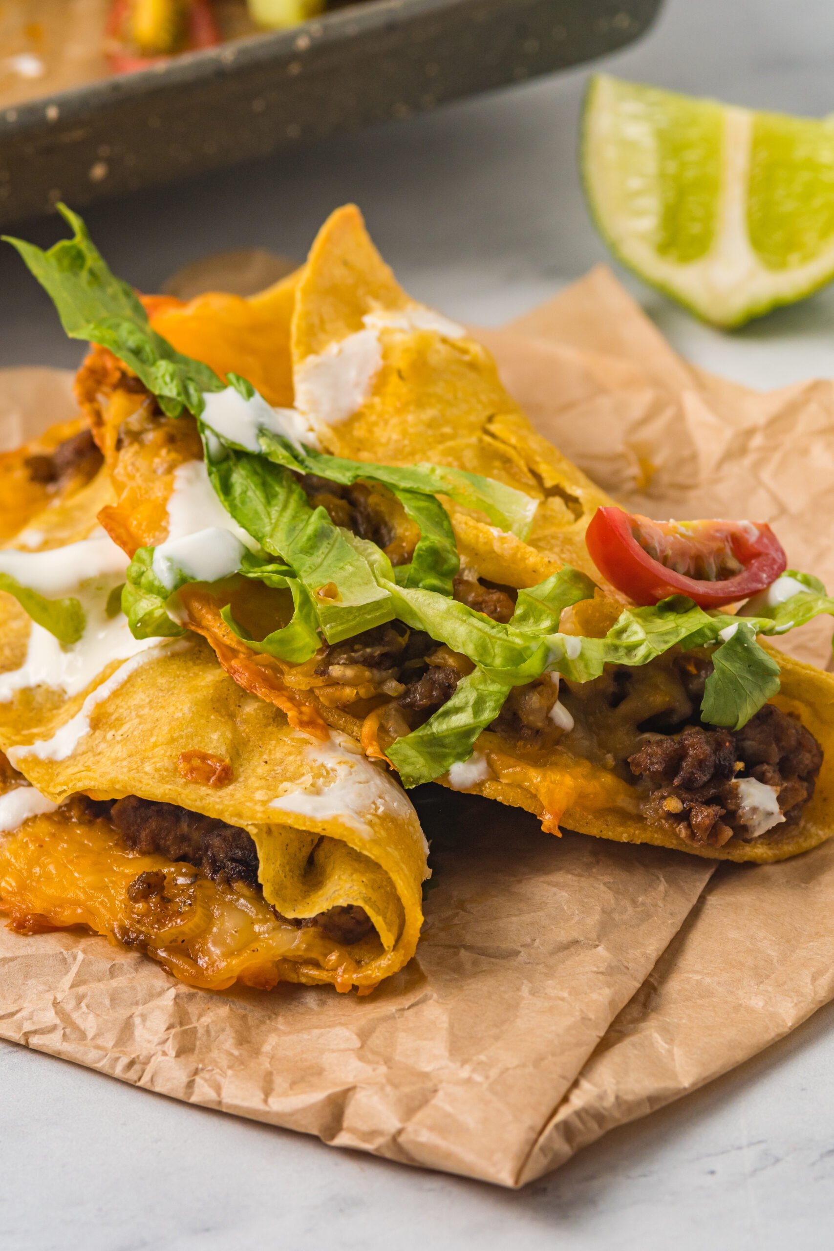 Front view of two Beef Tacos on parchment paper.