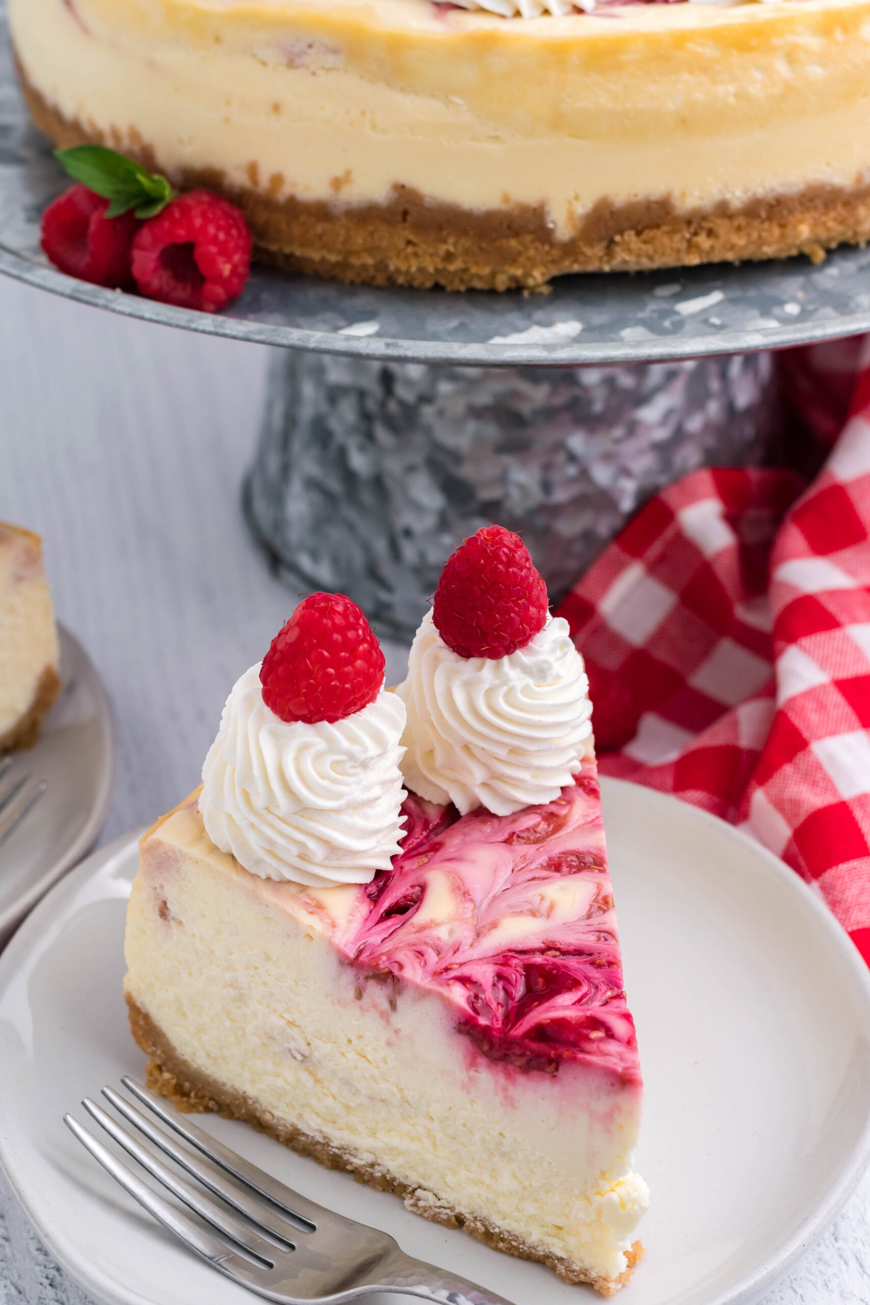Raspberry Swirl Cheesecake slice on a white dish.
