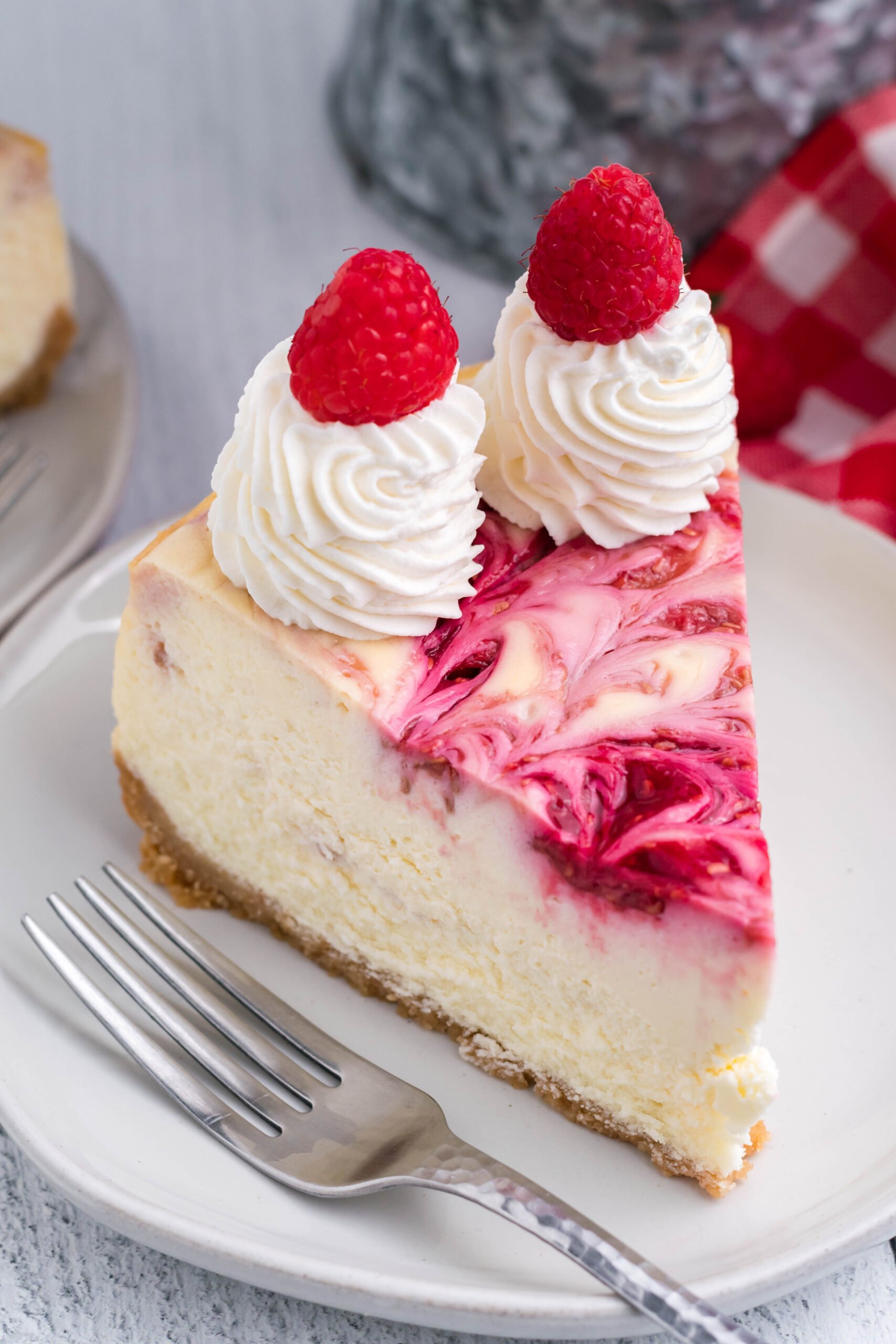 Raspberry Swirl Cheesecake slice on a white dish.