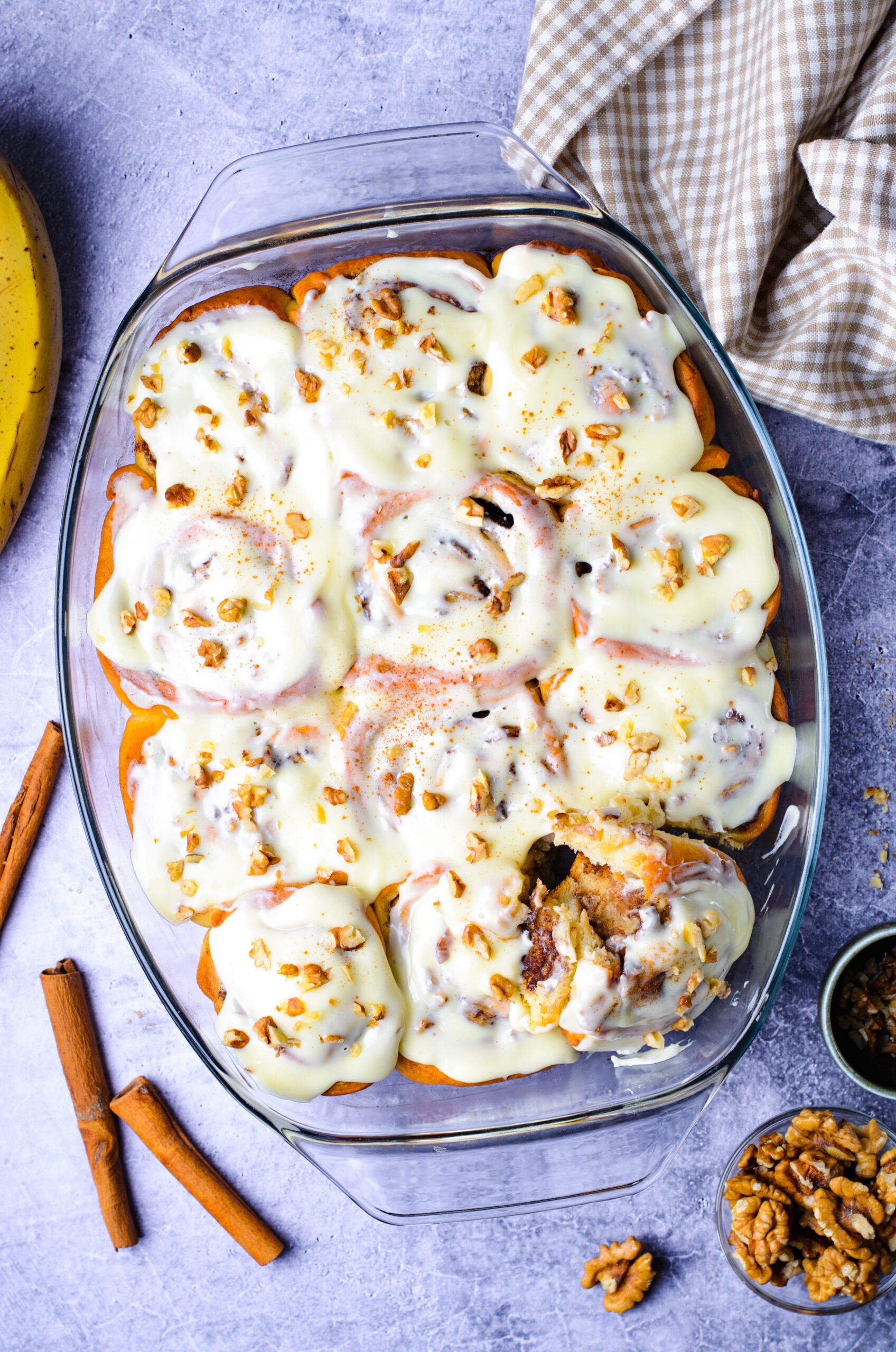 Overhead view of Banana Nut Cinnamon Rolls in a clear baking dish.