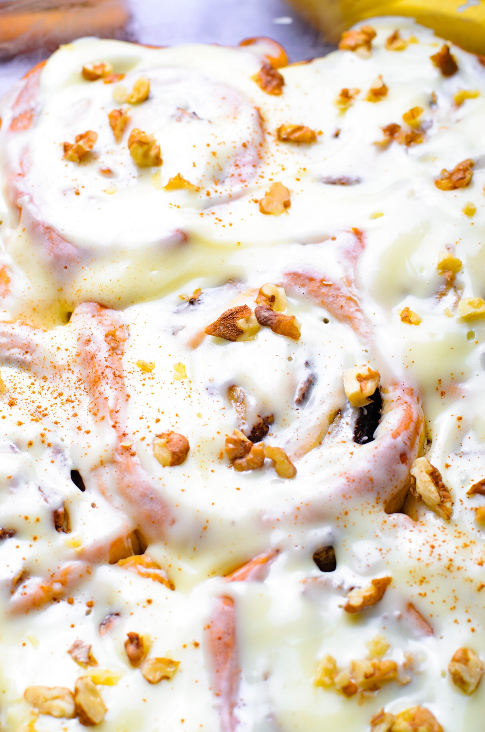 Close up view of Banana Nut Cinnamon Rolls in a clear baking dish.