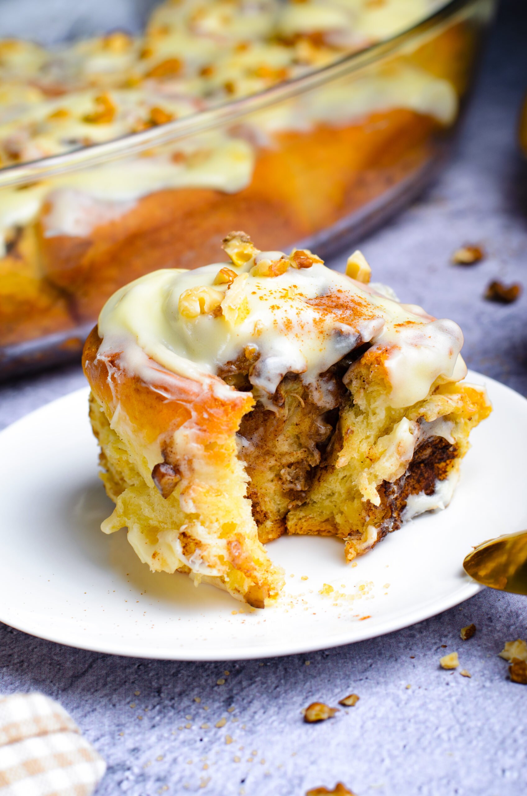Front view of a Banana Nut Cinnamon Roll  with a bite removed.