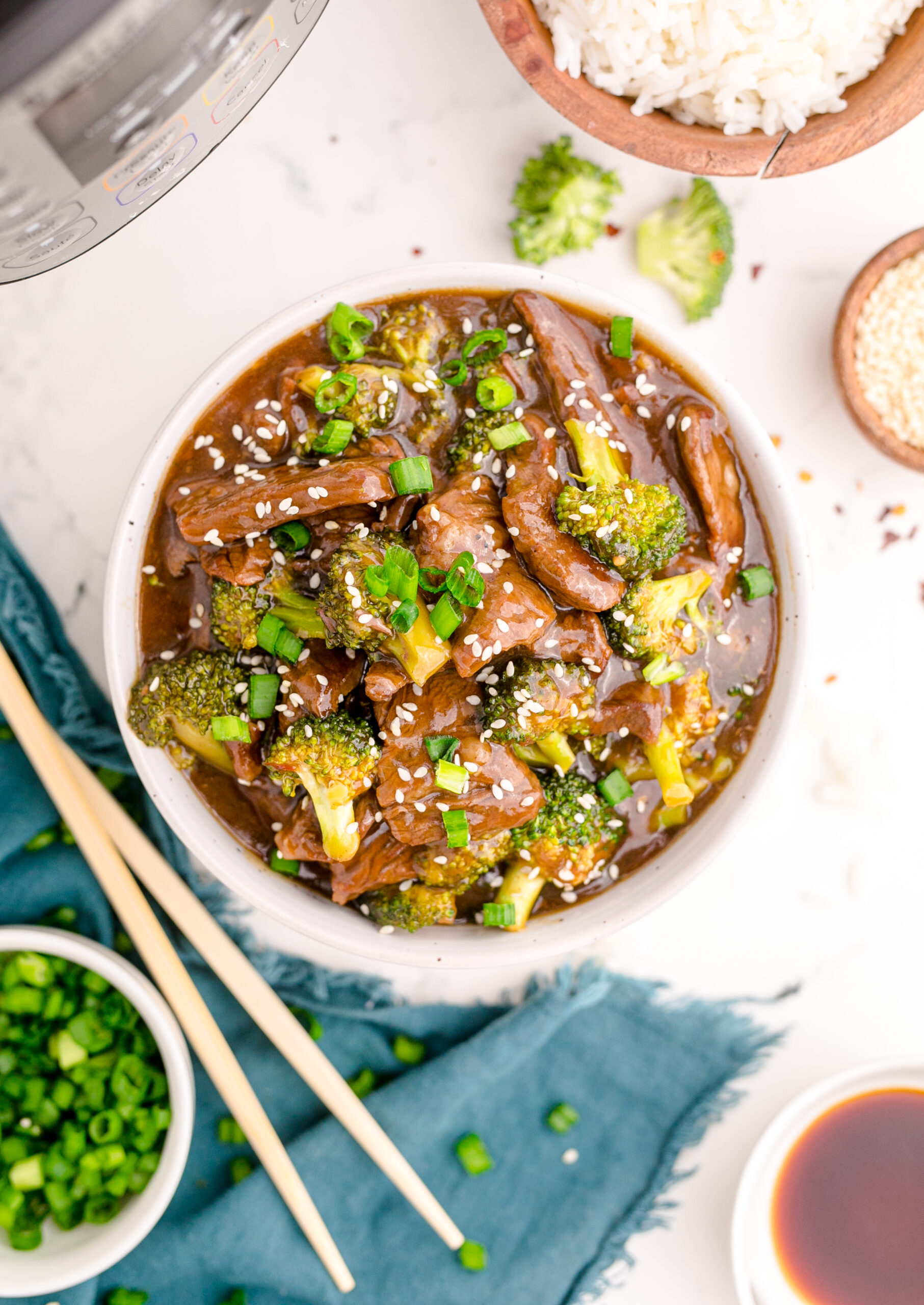 Overhead view of Instant Pot Beef and Broccoli in a white and tan bowl.