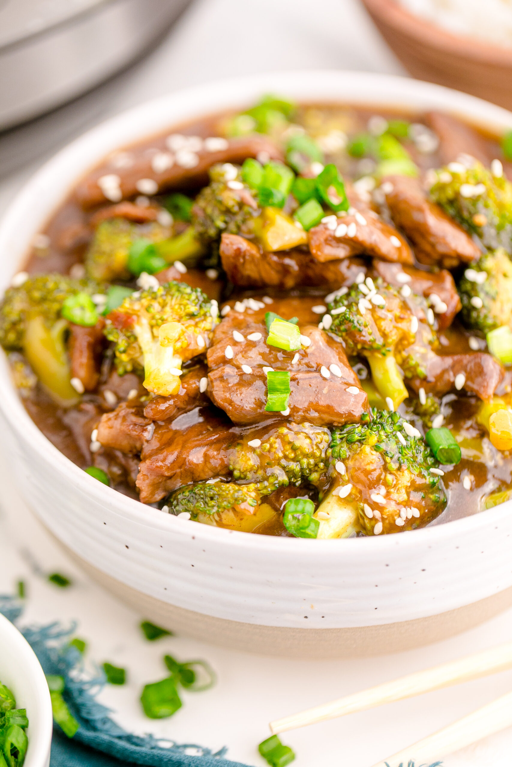 Up close view of Instant Pot Beef and Broccoli in a white and tan bowl.