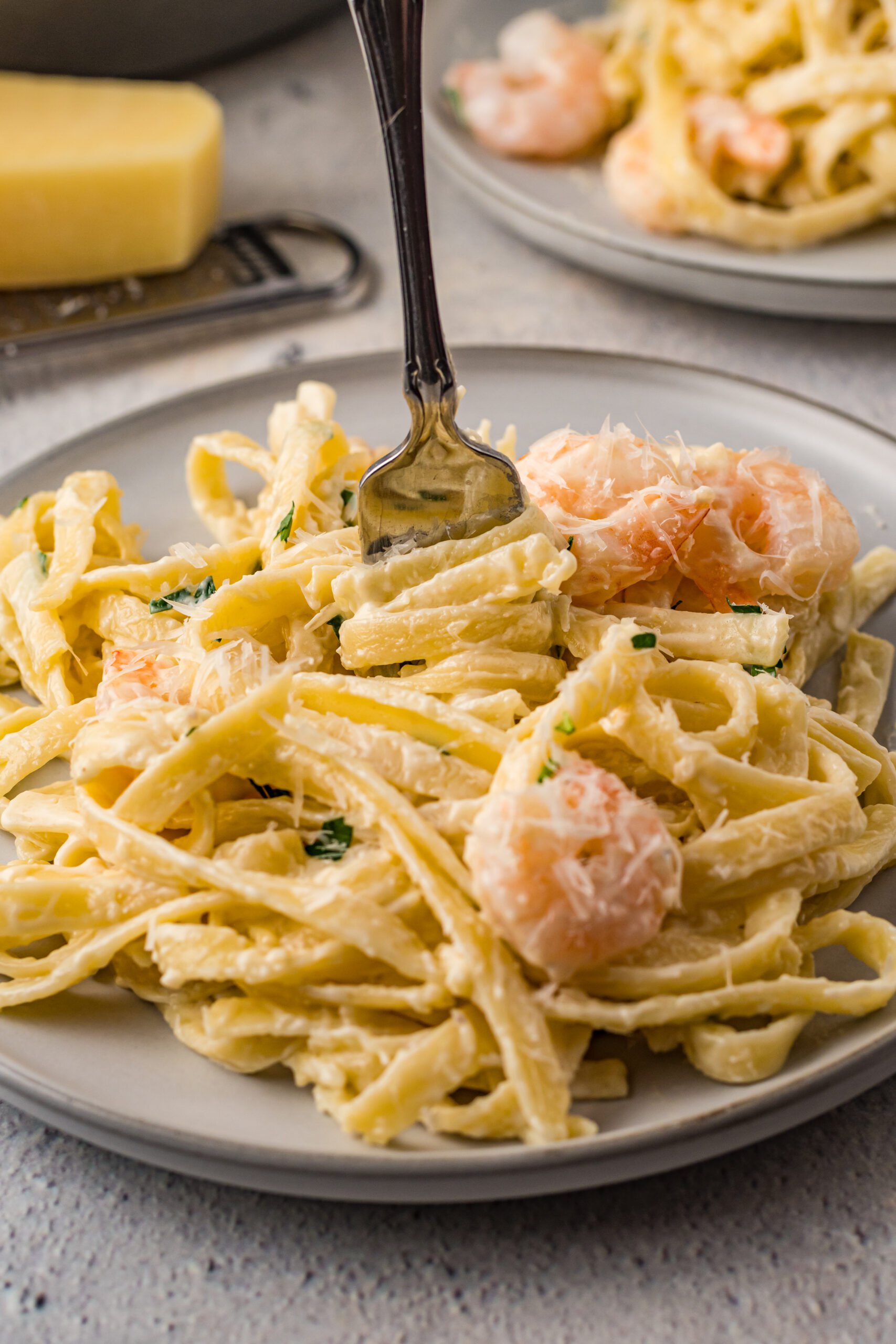 Front view of Shrimp Alfredo being swirled around a silver fork.