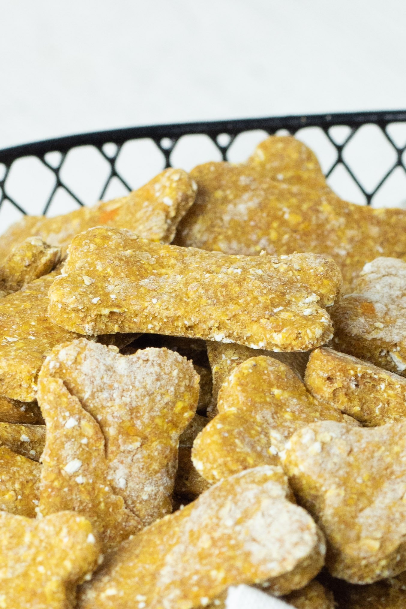 Close up view of Sweet Potato and Pumpkin Dog Treats in a wire basket lined with linen.