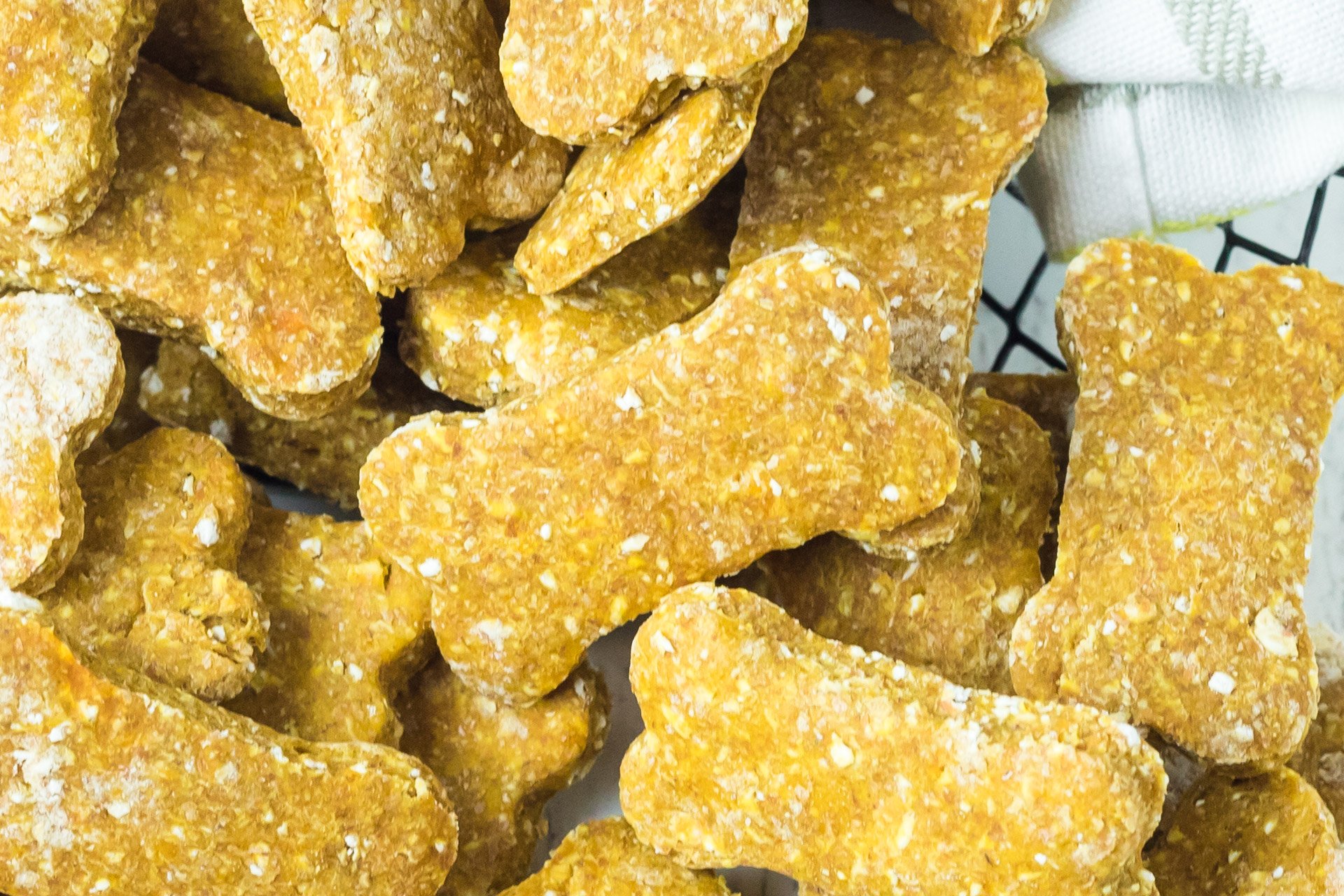 Close up view of Sweet Potato and Pumpkin Dog Treats in a wire basket lined with linen.