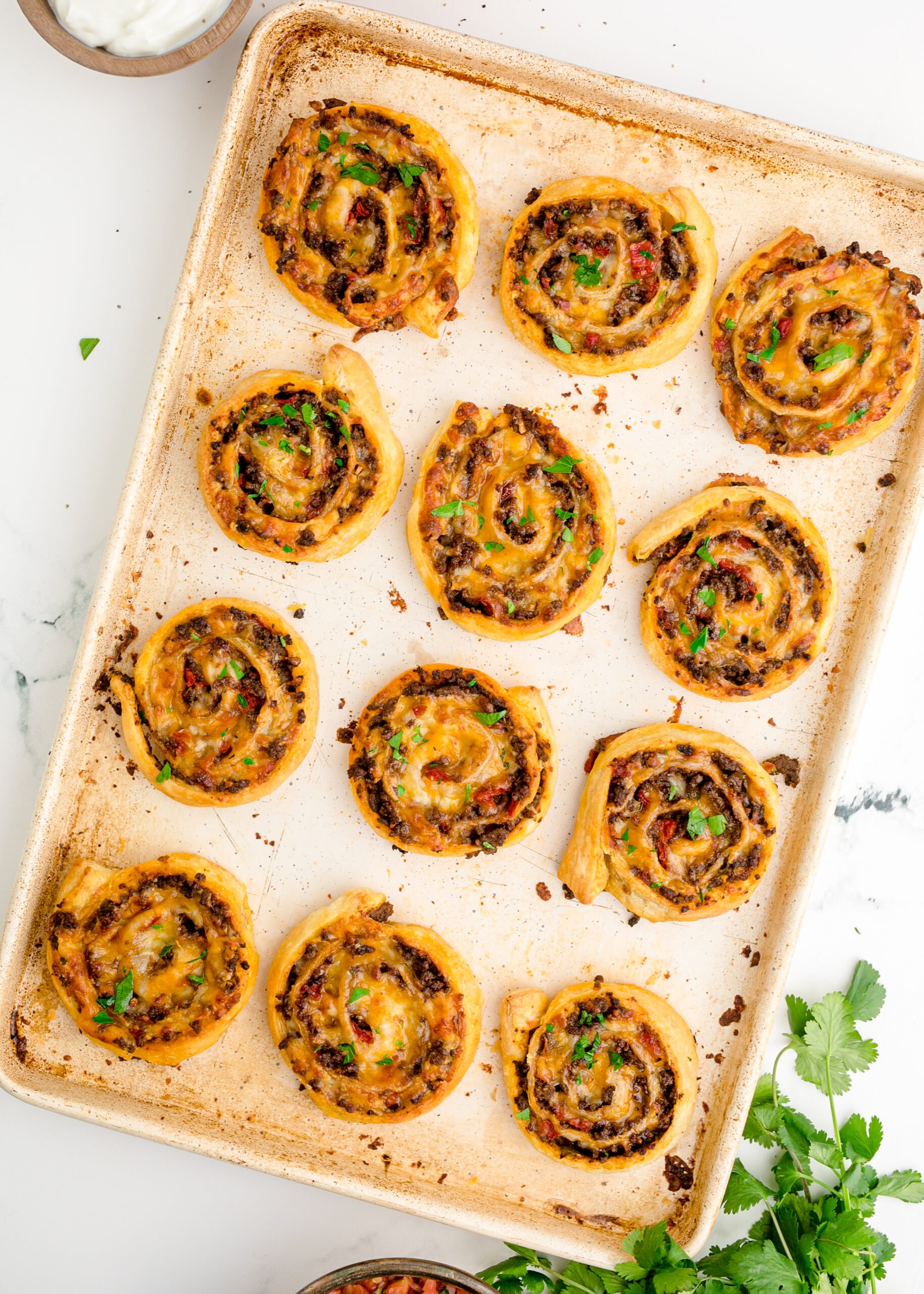 Overhead view of Taco Pinwheels on a baking sheet pan.