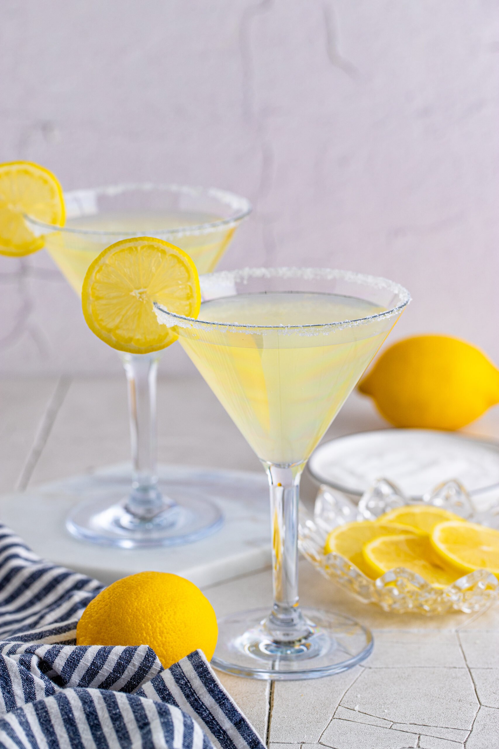 Two Lemon Drop Martinis in martini glasses with a lemon slice. 