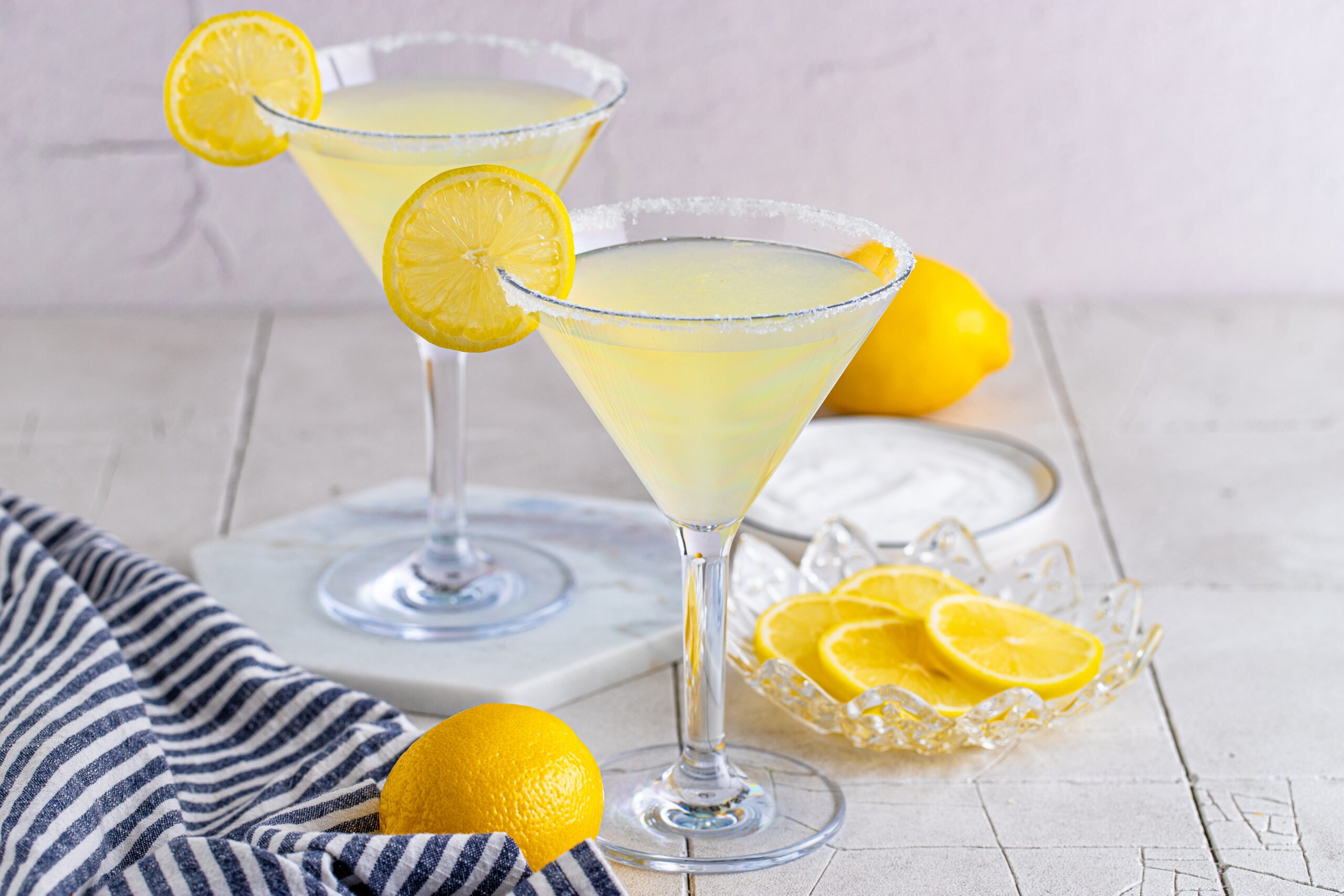 Two Lemon Drop Martinis in martini glasses with a lemon slice. 