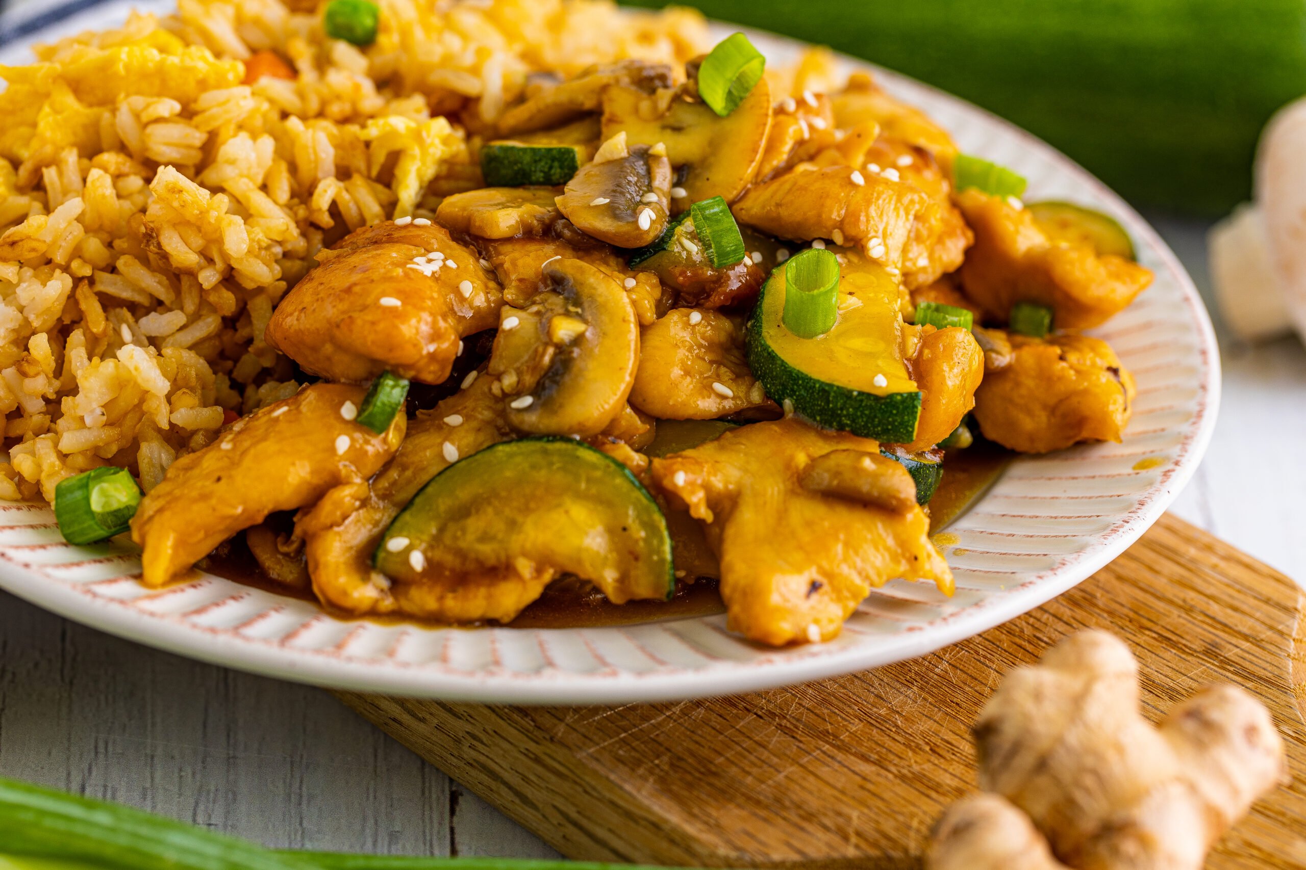 Front view of Panda Express Mushroom Chicken on a white dish served with fried rice.