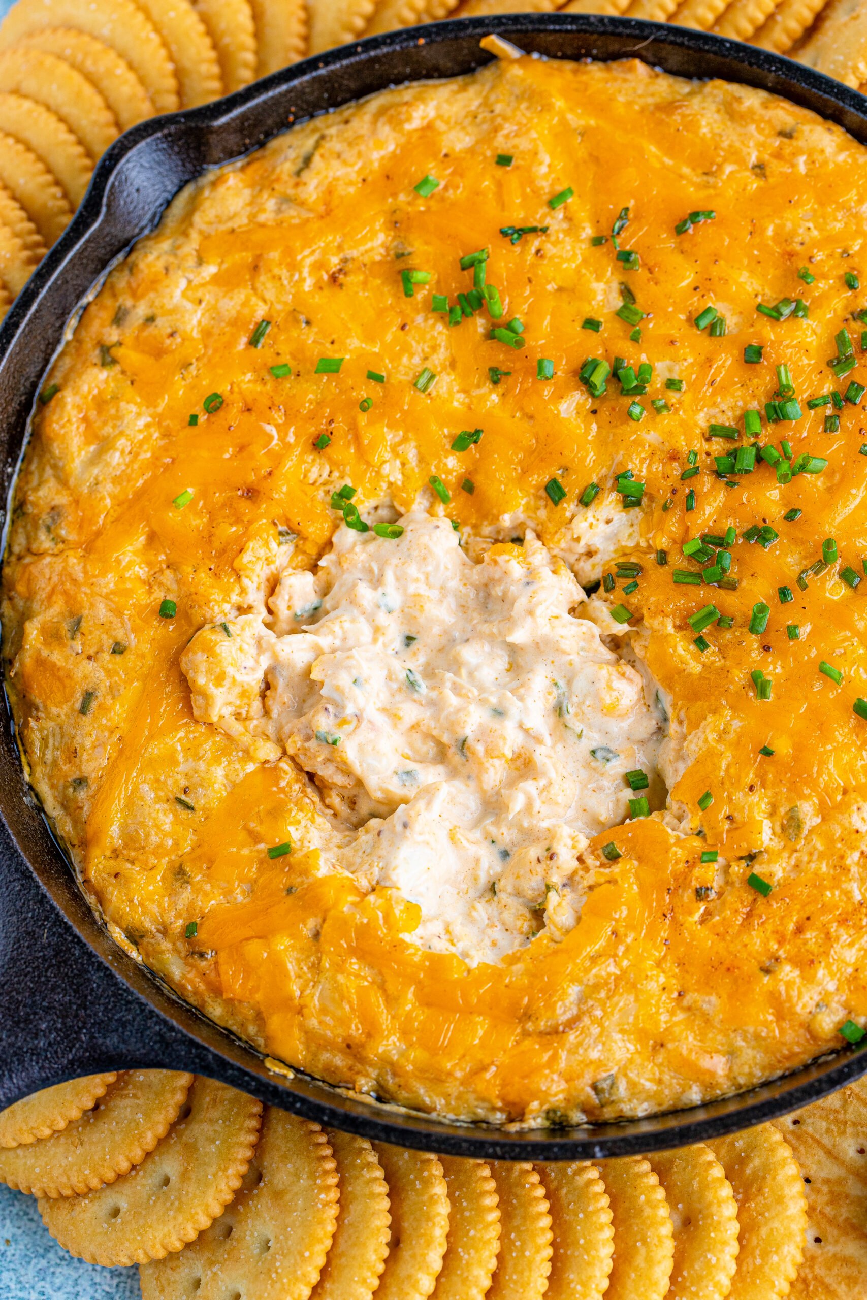 Overhead view of Crab Dip Recipe in a cast iron skillet served with crackers.