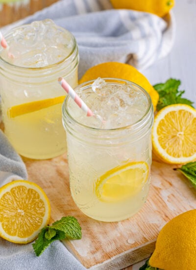 Real Homemade Lemonade in two mason jar cups with sliced lemons