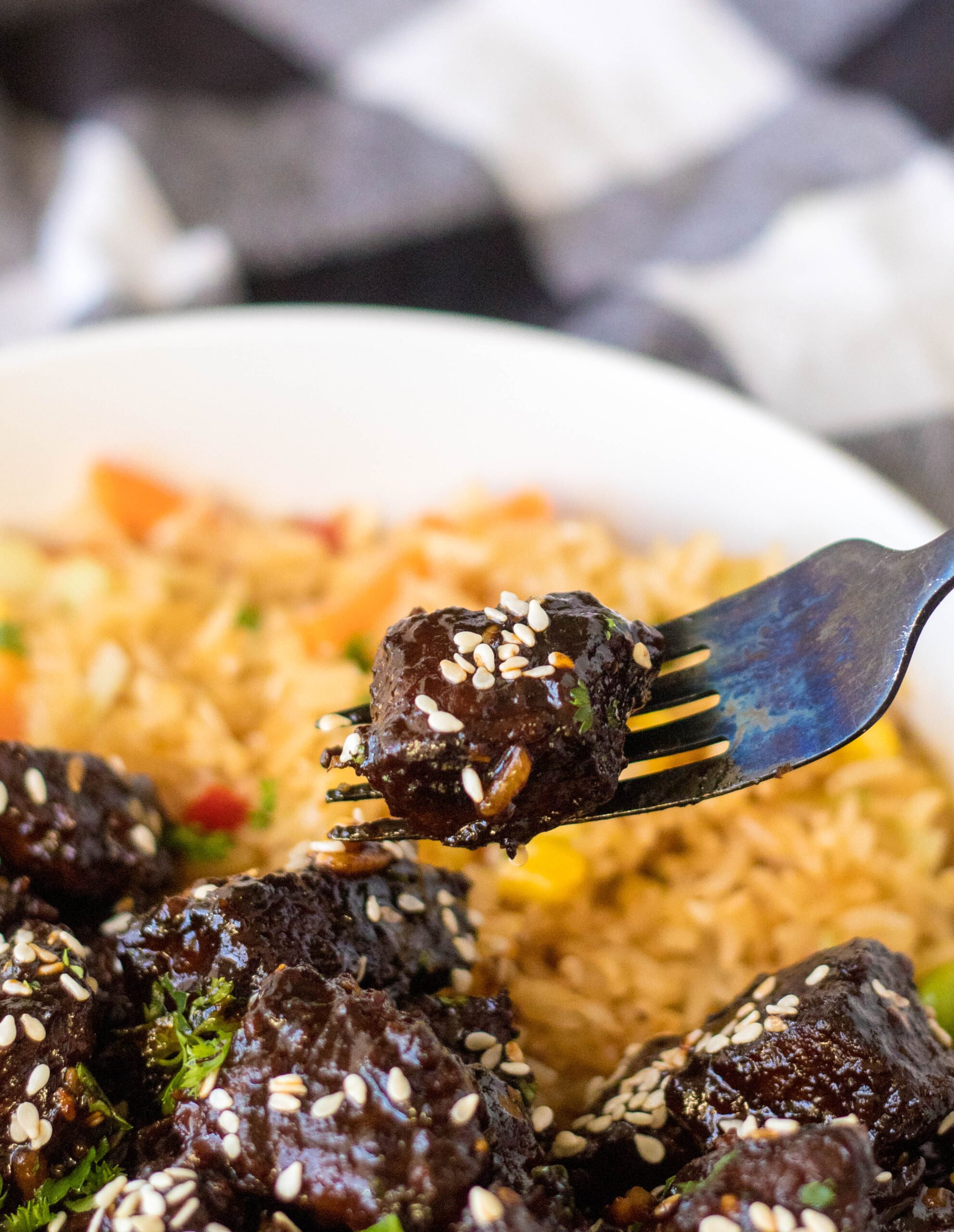 Close up view of a piece of Slow Cooker Honey Garlic Steak Bites on a black fork.