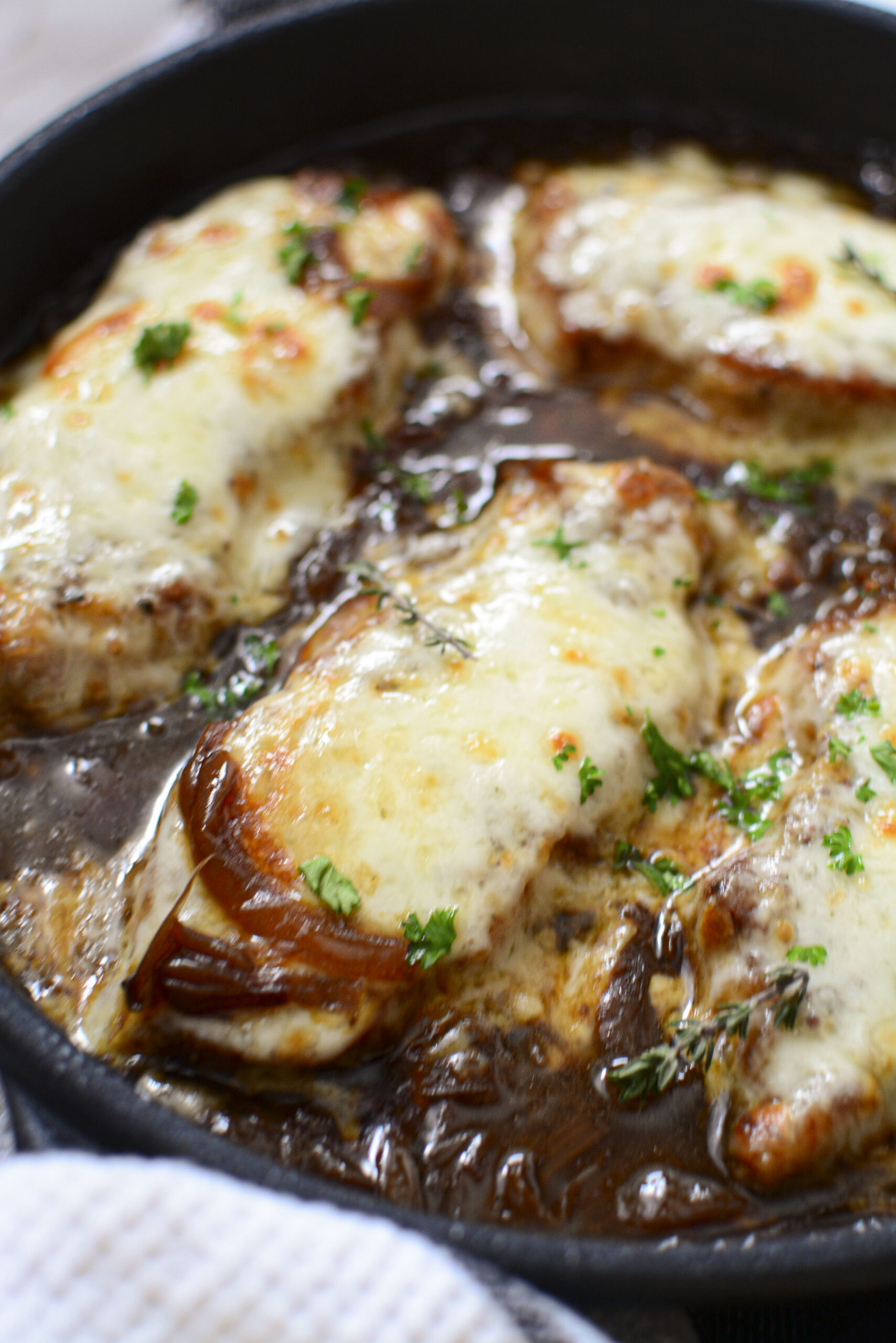 Close up view of French Onion Pork Chops in a cast iron skillet.