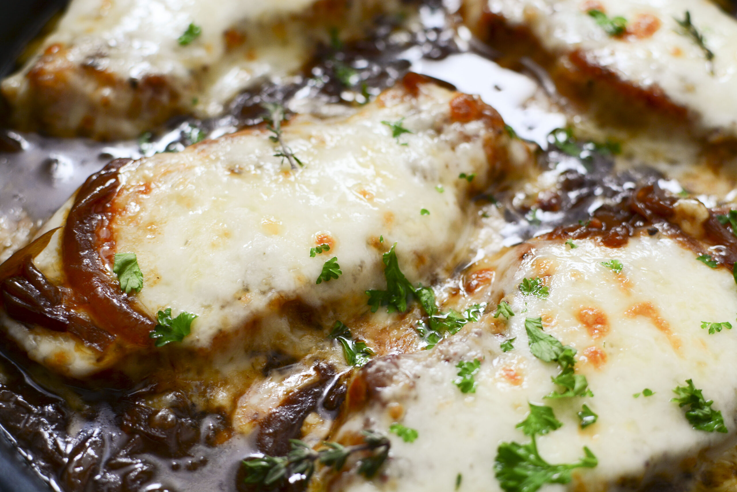 Close up view of French Onion Pork Chops in a cast iron skillet.
