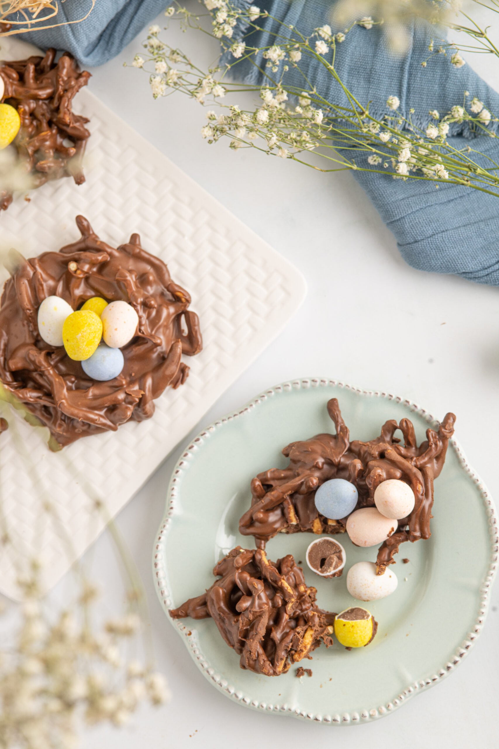 Overhead shot of a cookie cut in half on a teal plate.
