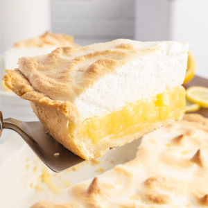 homemade lemon meringue pie slice being lifted