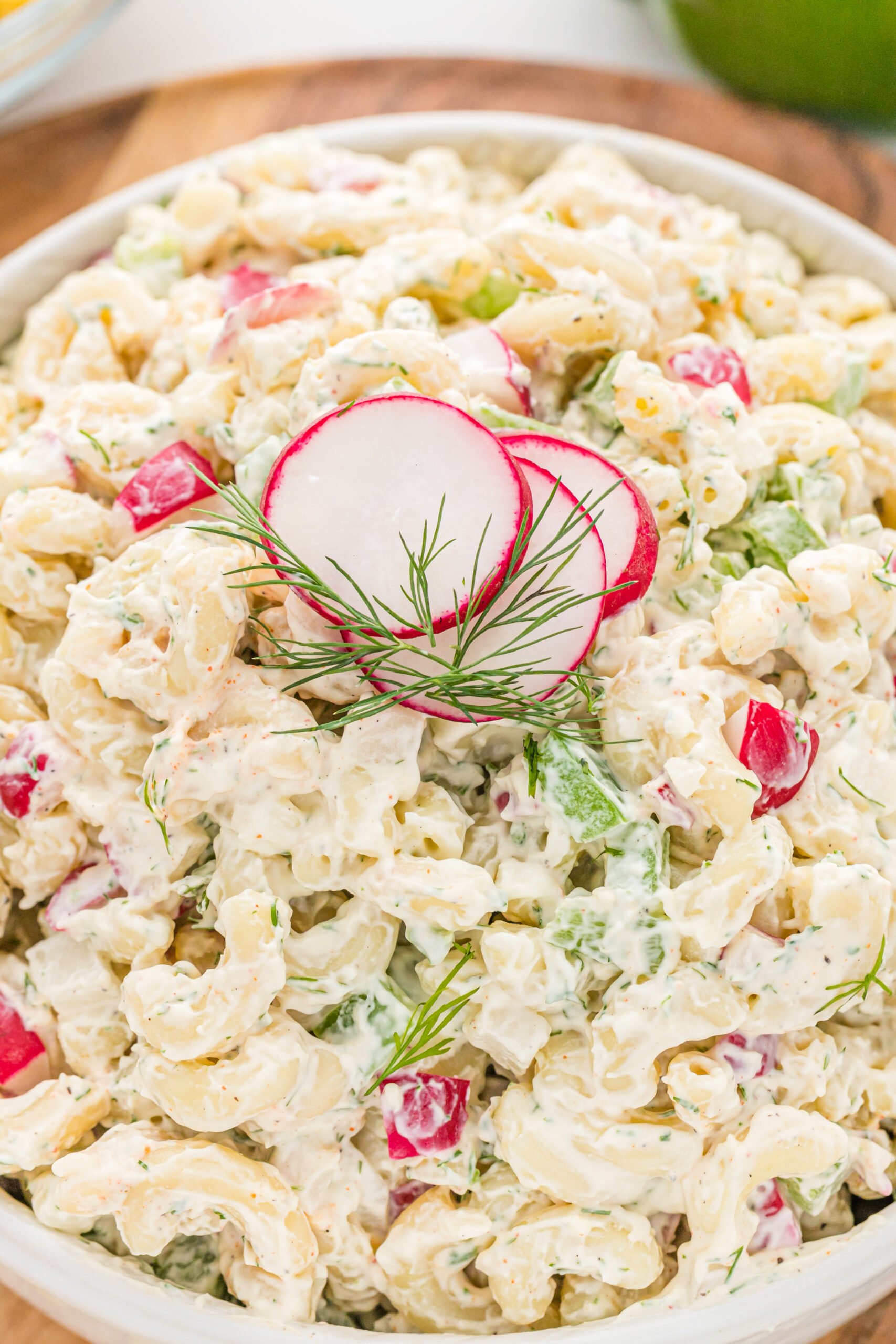 Close up view of Macaroni Dill Pasta Salad in a white serving bowl.