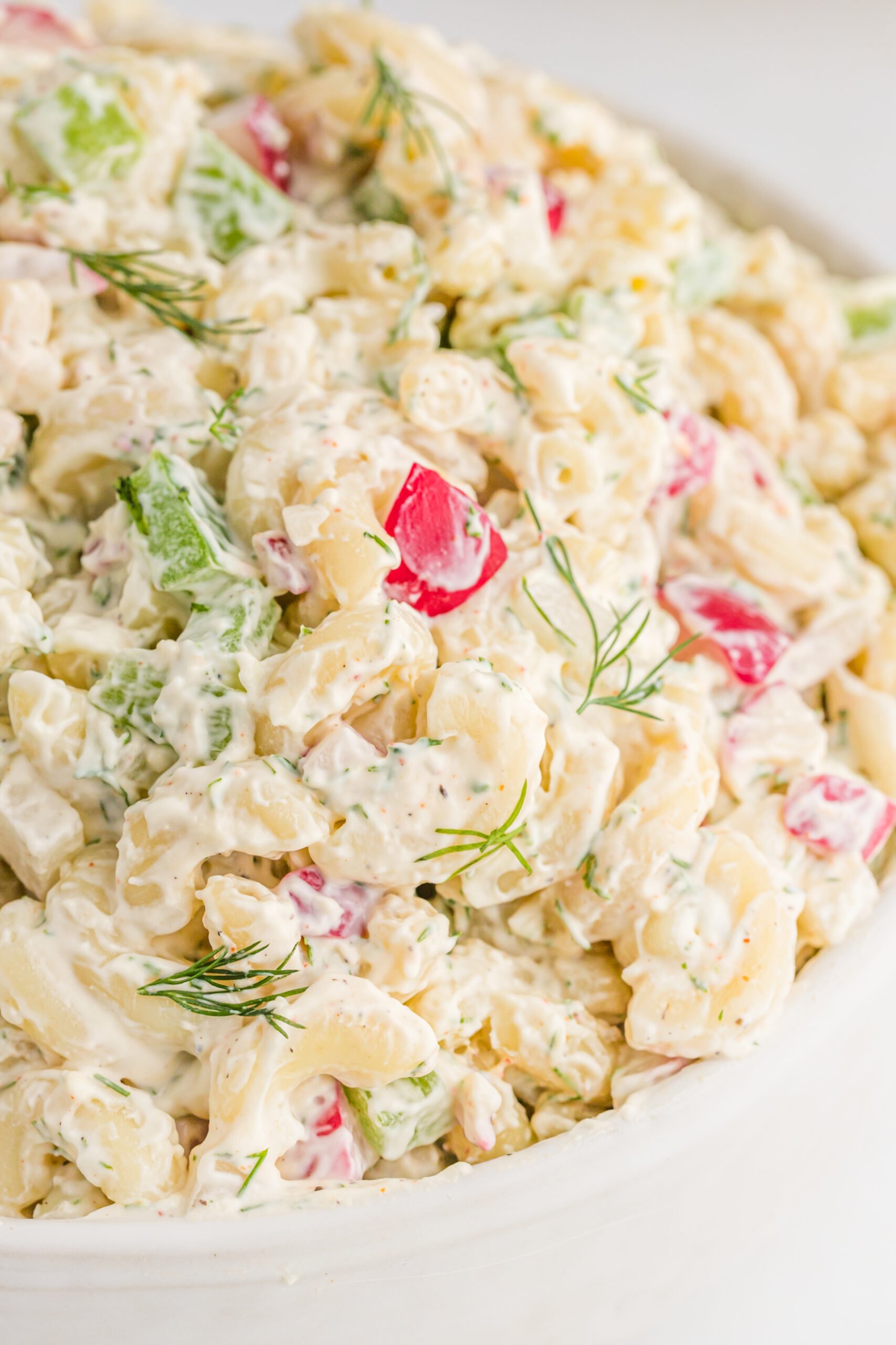 Close up view of Macaroni Dill Pasta Salad in a white serving bowl.