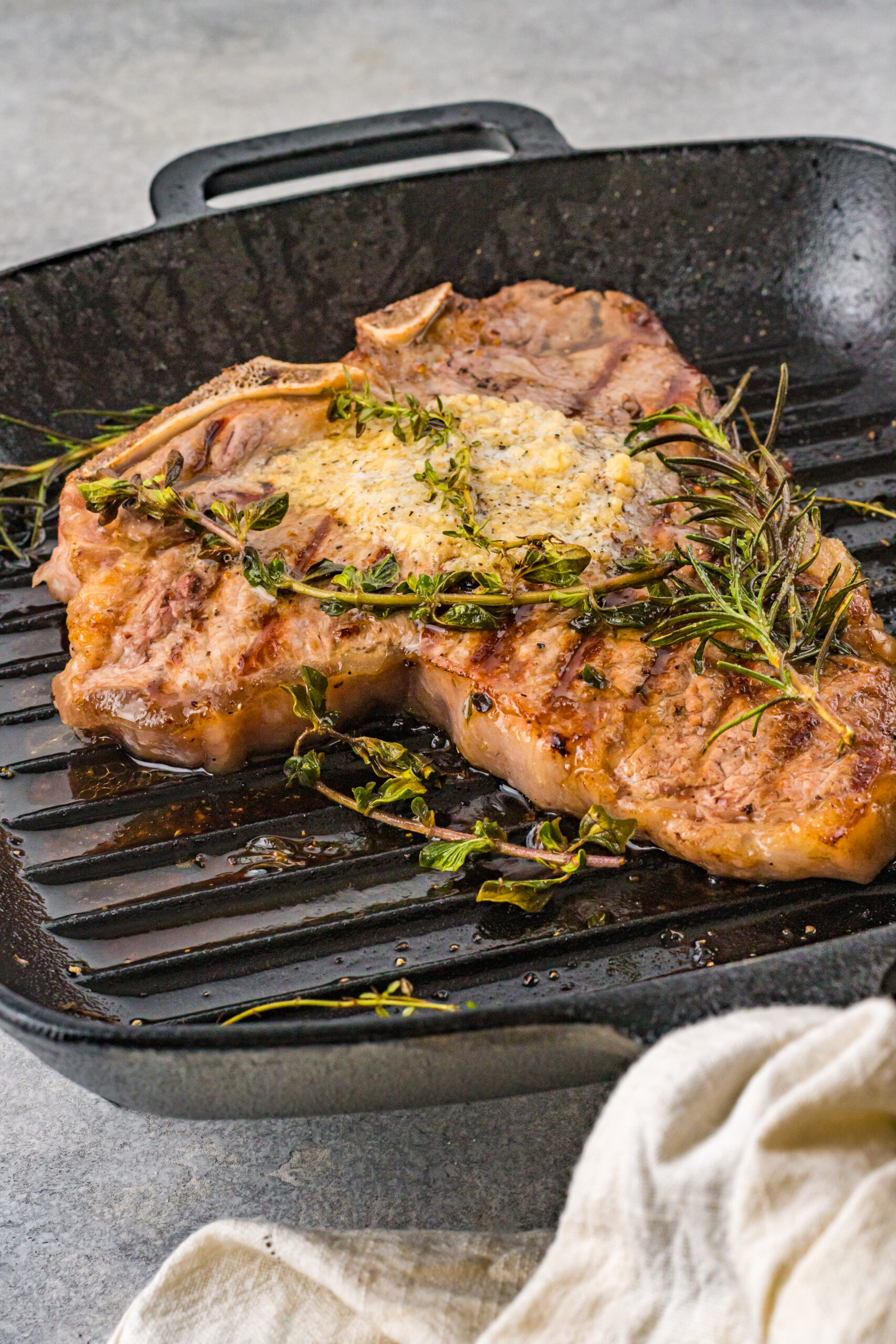 Front view of T Bone Steak in a cast iron skillet.