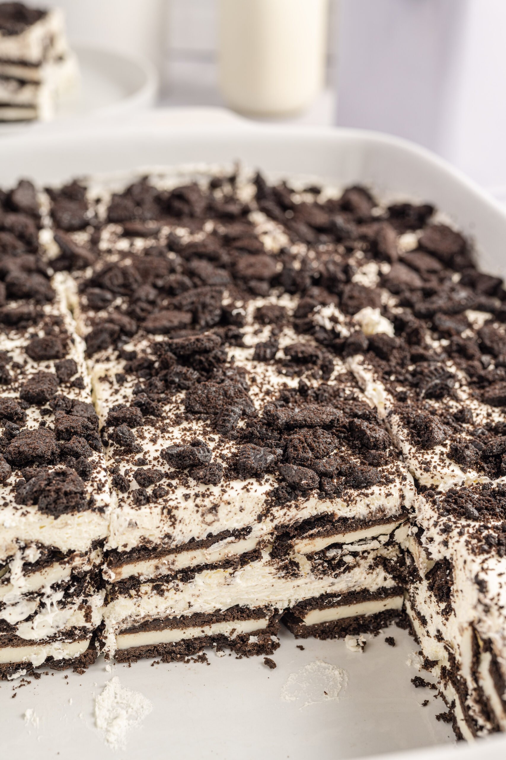 Close up view of Oreo Icebox Cake with two slices removed in a white baking dish.