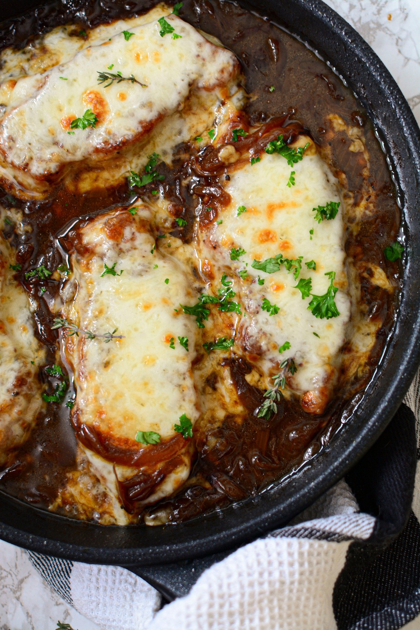 Close up view of French Onion Pork Chops in a cast iron skillet.