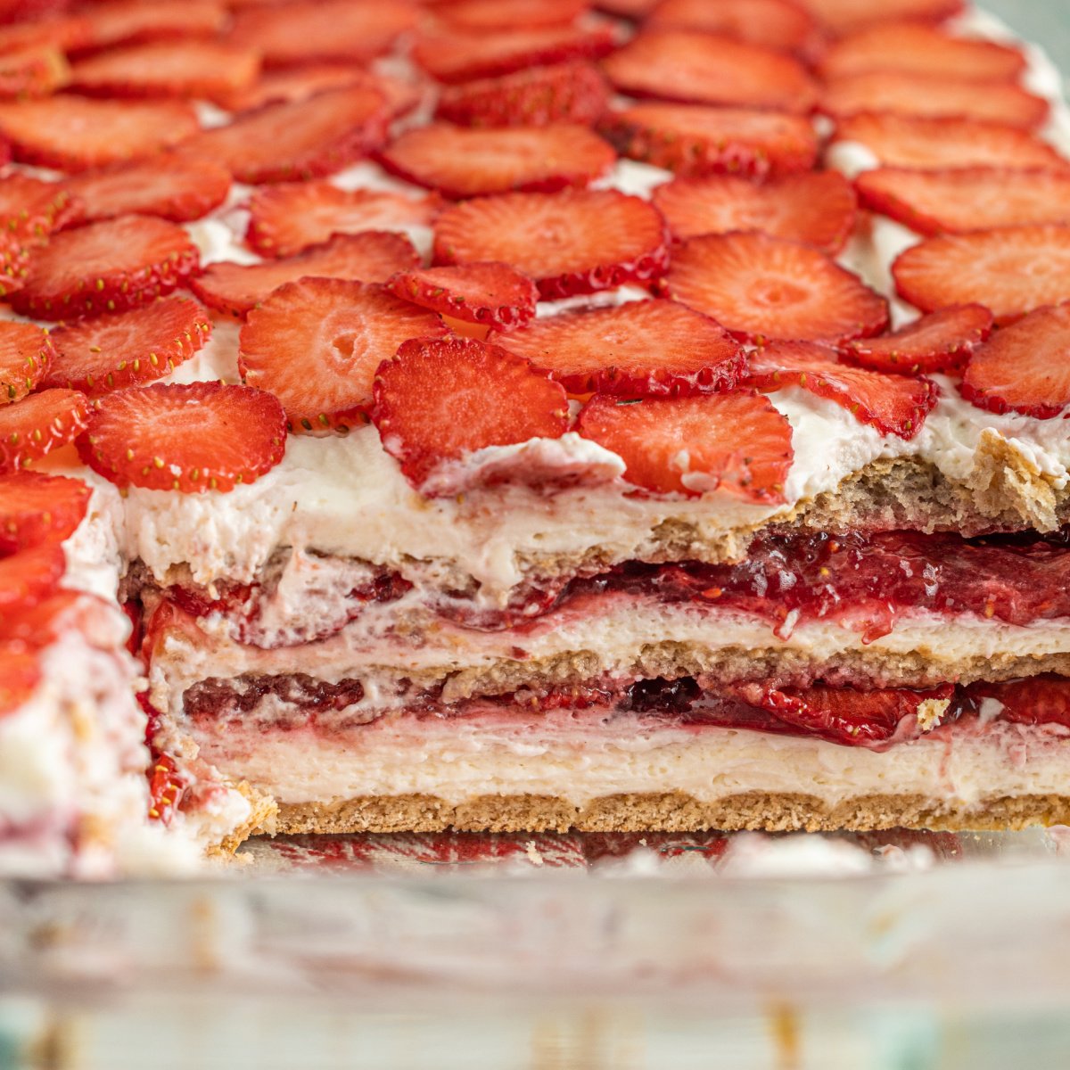 strawberry cheesecake icebox cake up close with a slice removed to show the layers 