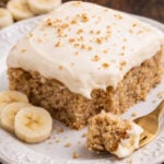 Banana Sheet Cake on a white plate with a bite missing