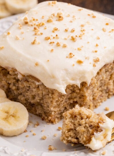 Banana Sheet Cake on a white plate with a bite missing