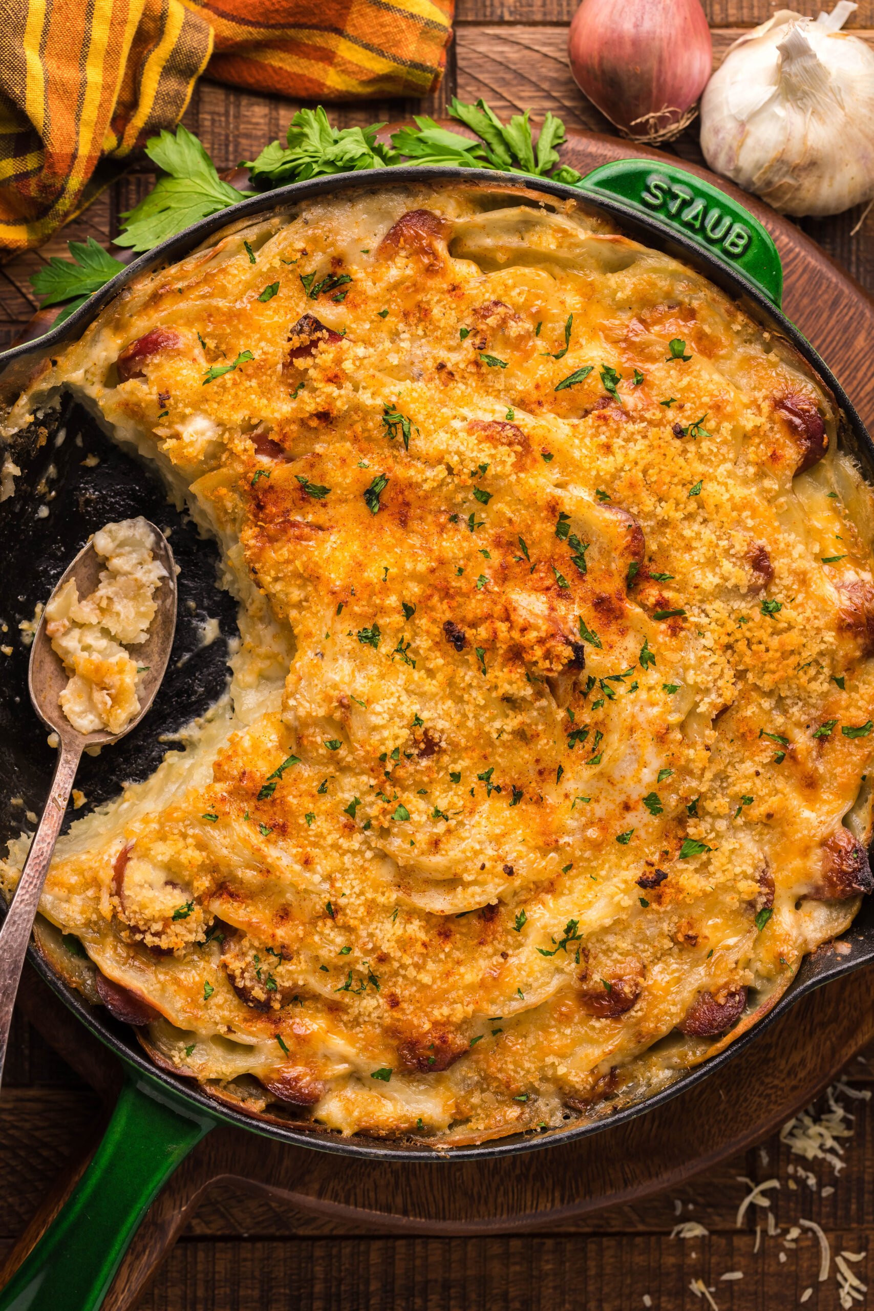Overhead view of Au Gratin Potatoes & Ham in a cast iron skillet with a serving removed.