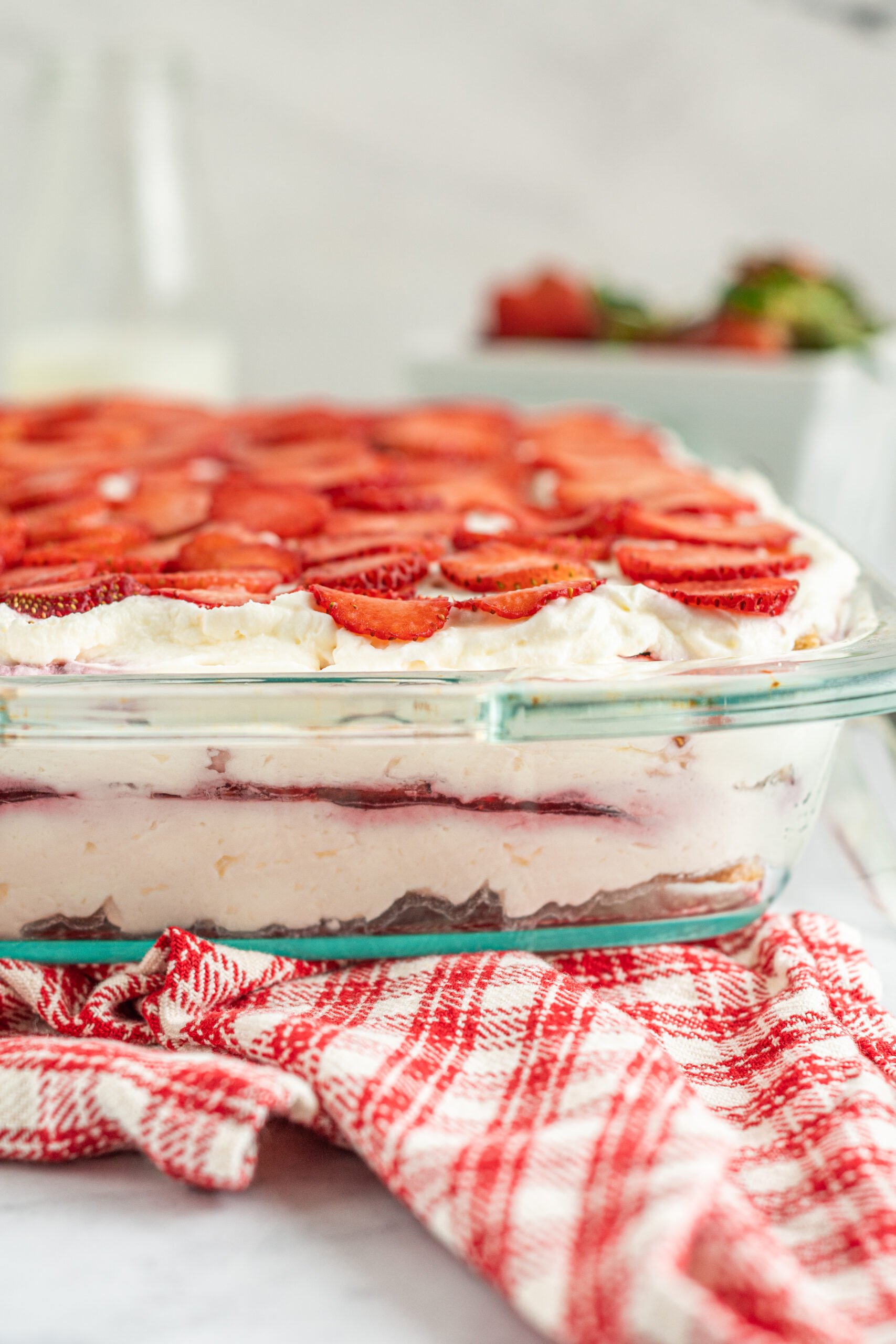 Close up side view of Strawberry Icebox Cake in a clear baking dish. 