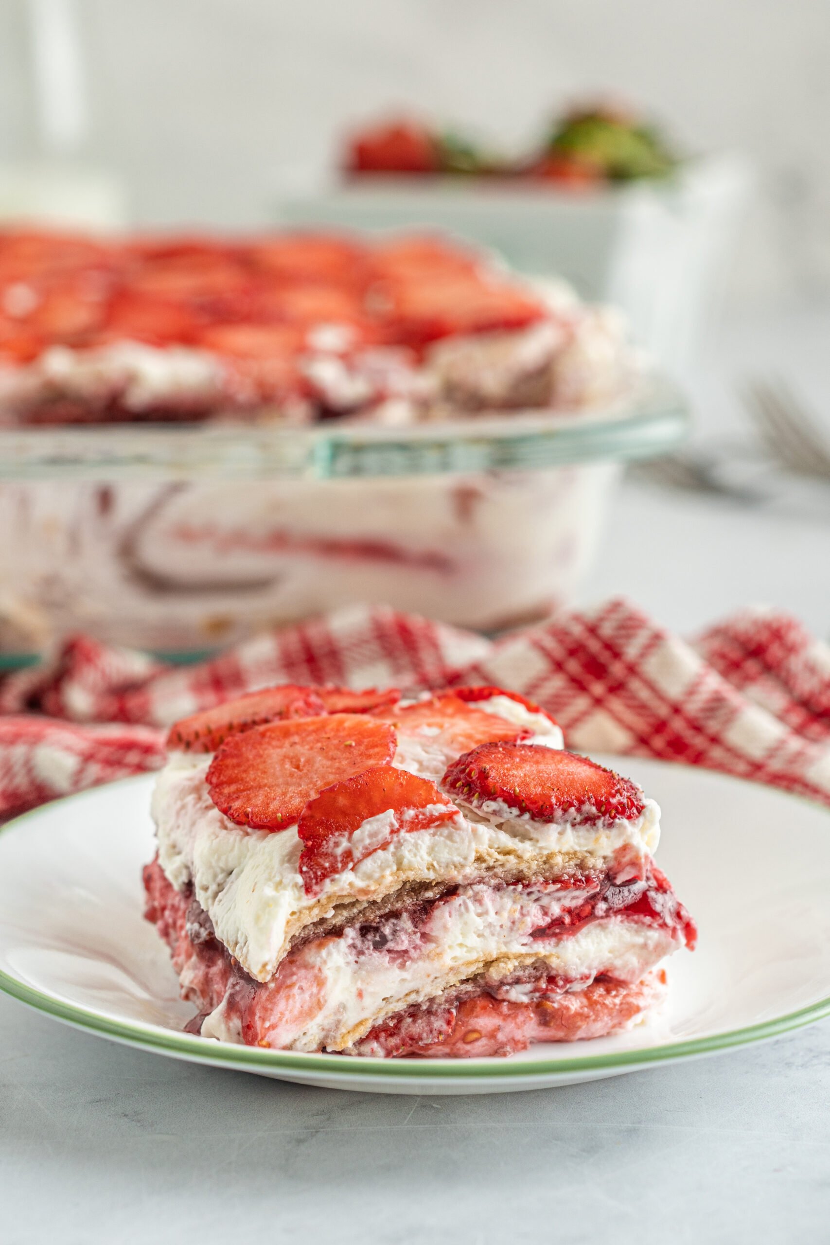 A piece of Strawberry Icebox Cake on a white and green plate. 