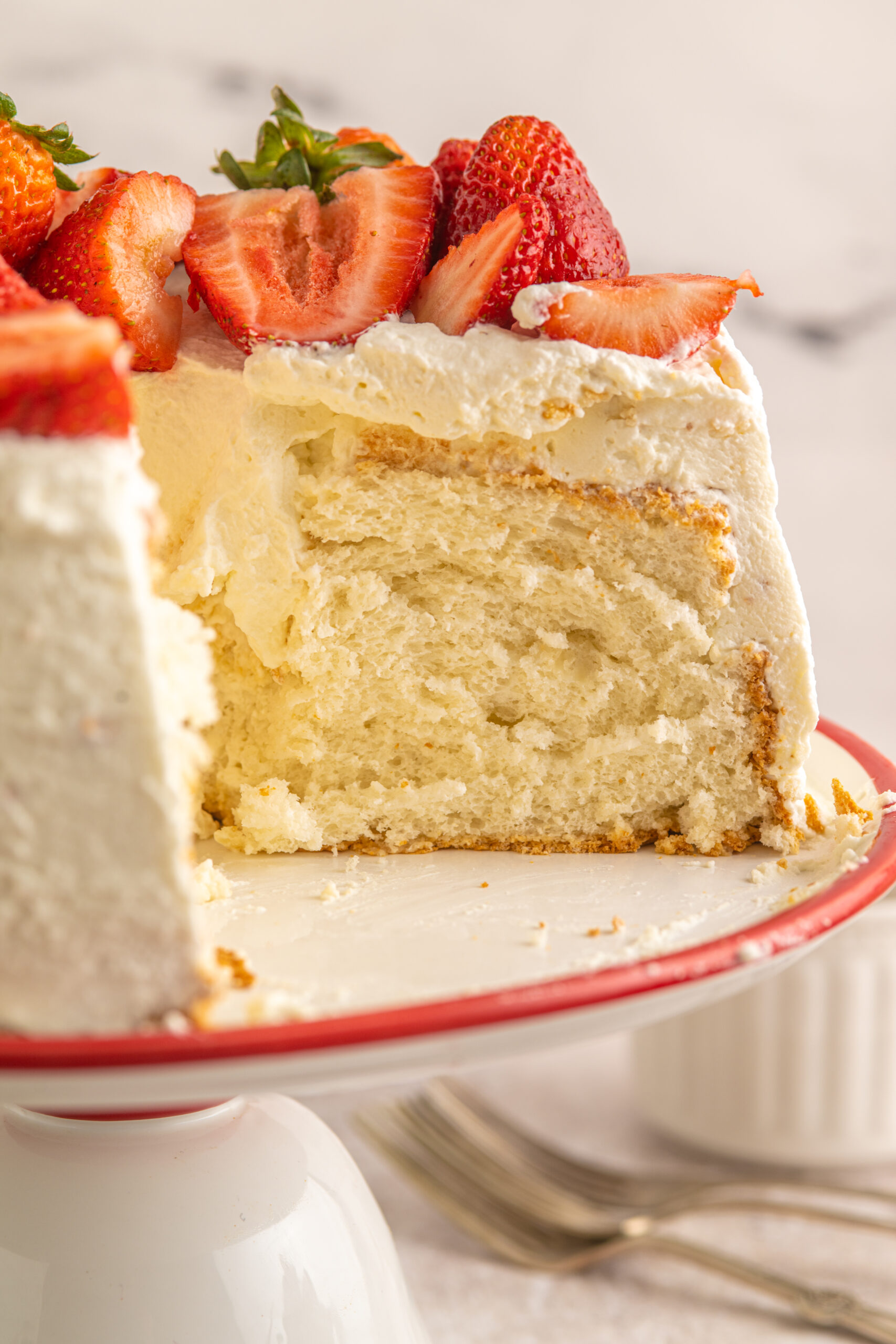 Side view of a cut piece of Strawberry Angel Food Cake showing the inside of the cake. 