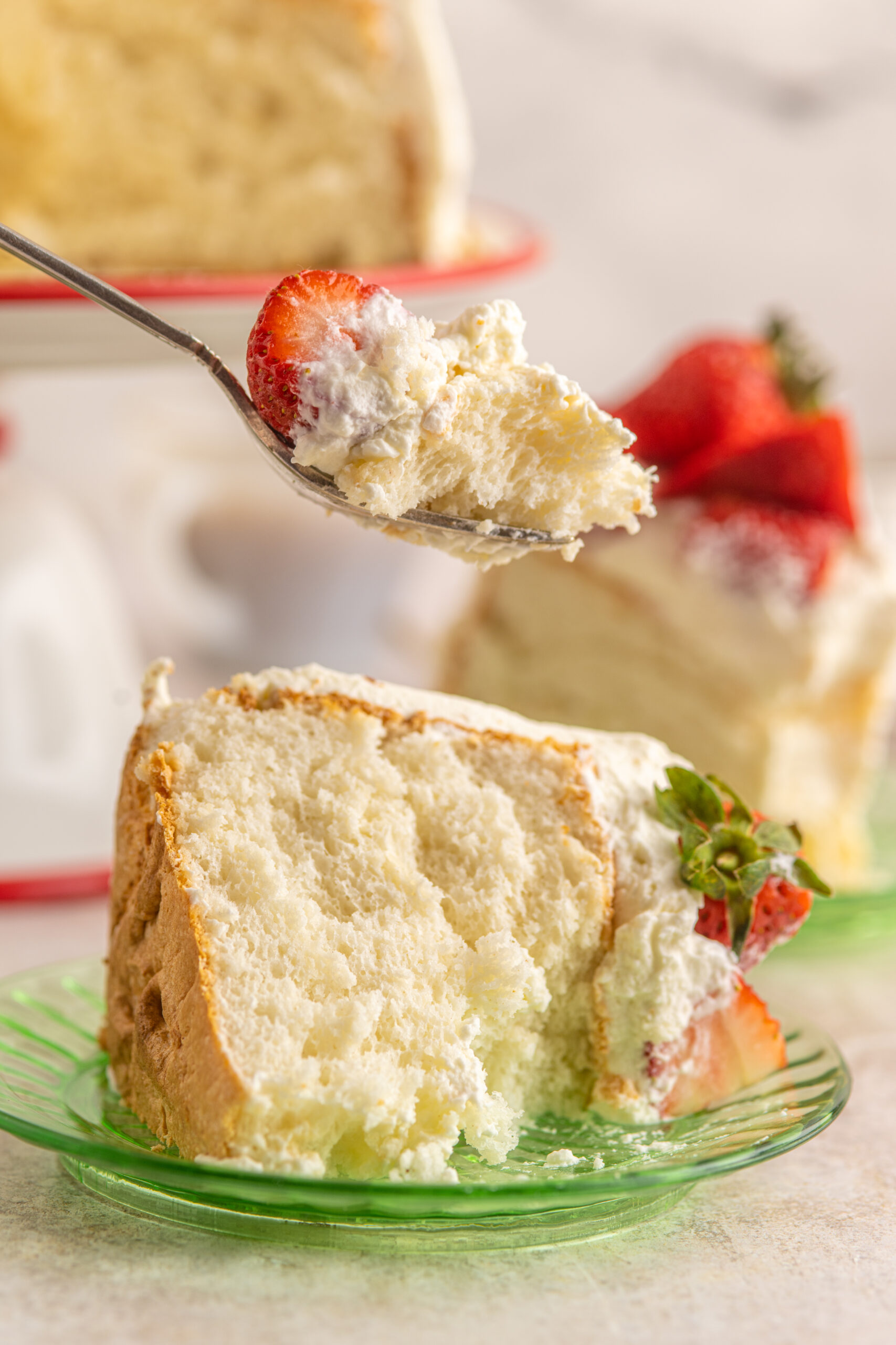 A silver fork removing a bite of Strawberry Angel Food Cake.